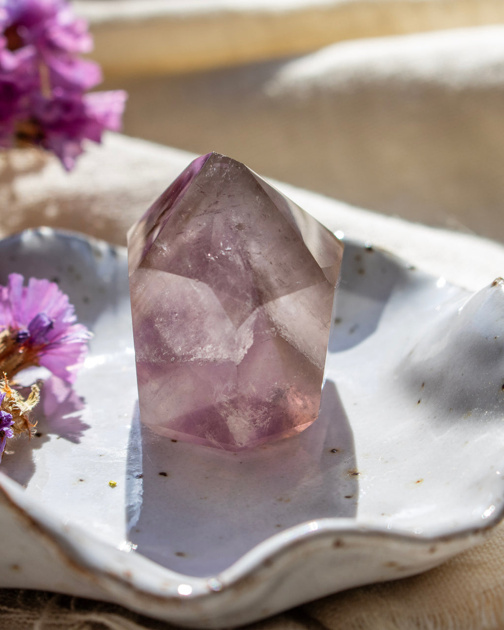 Crystal on a white dish with purple flowers