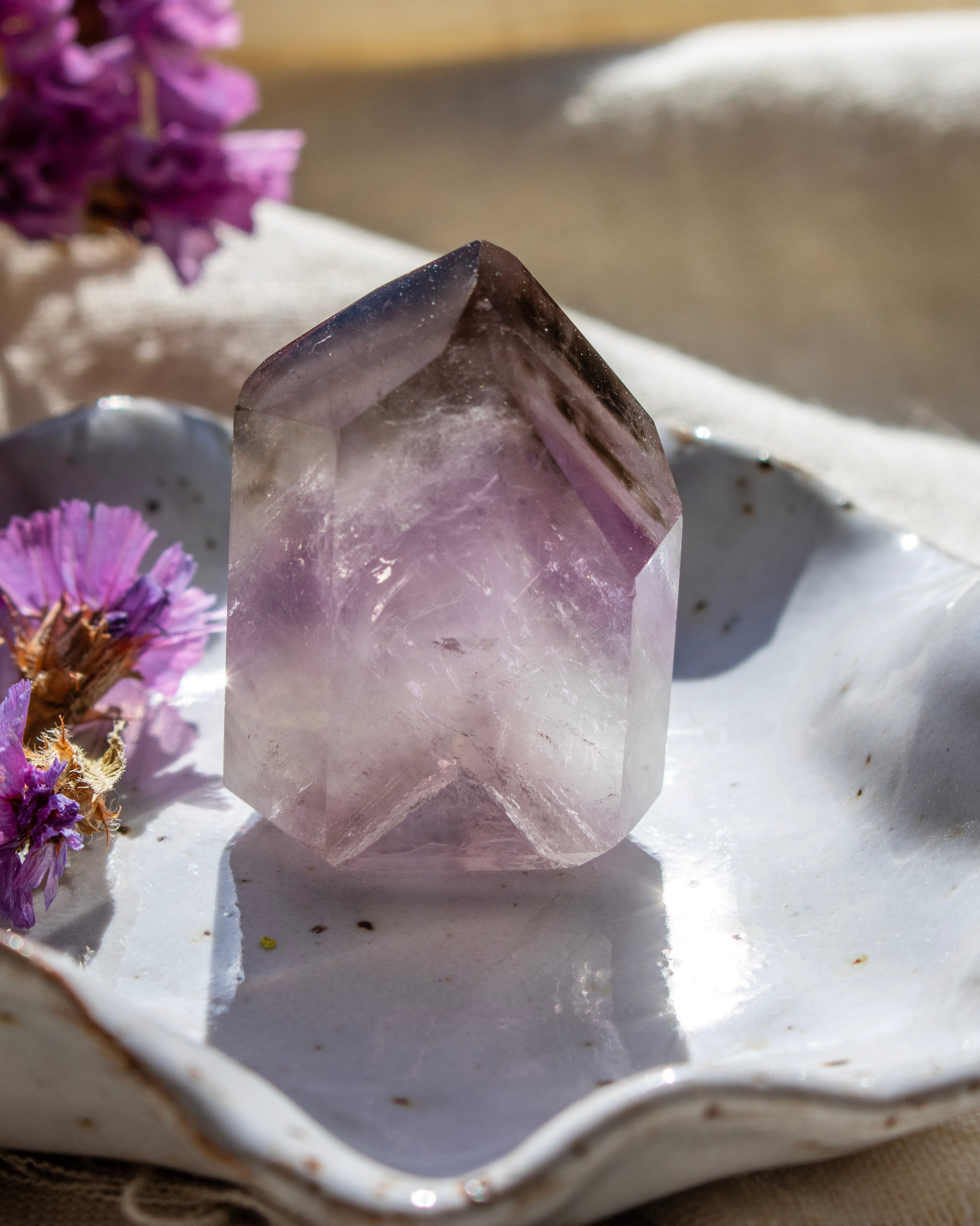 Crystal on a white dish with purple flowers