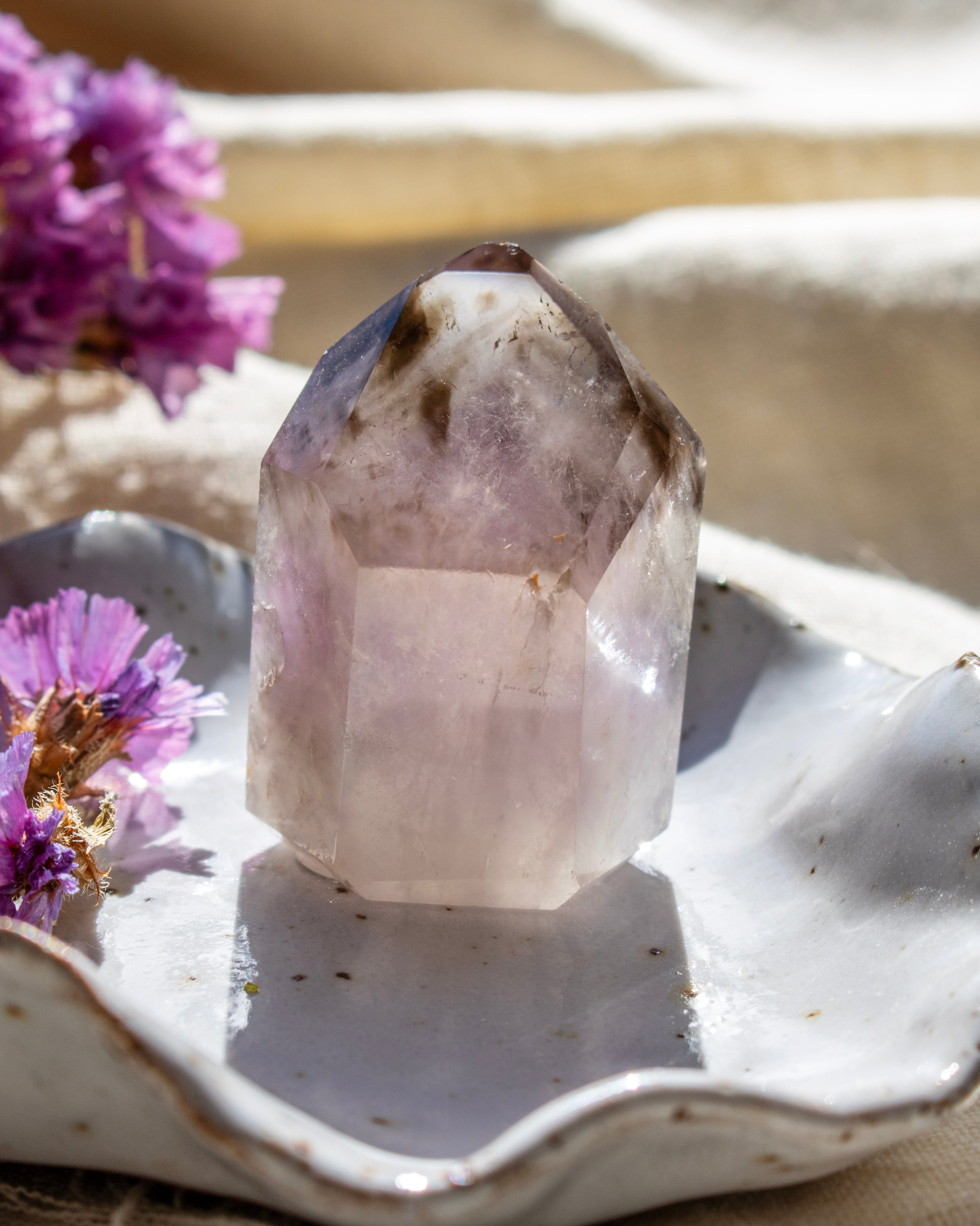Crystal on a white dish with purple flowers