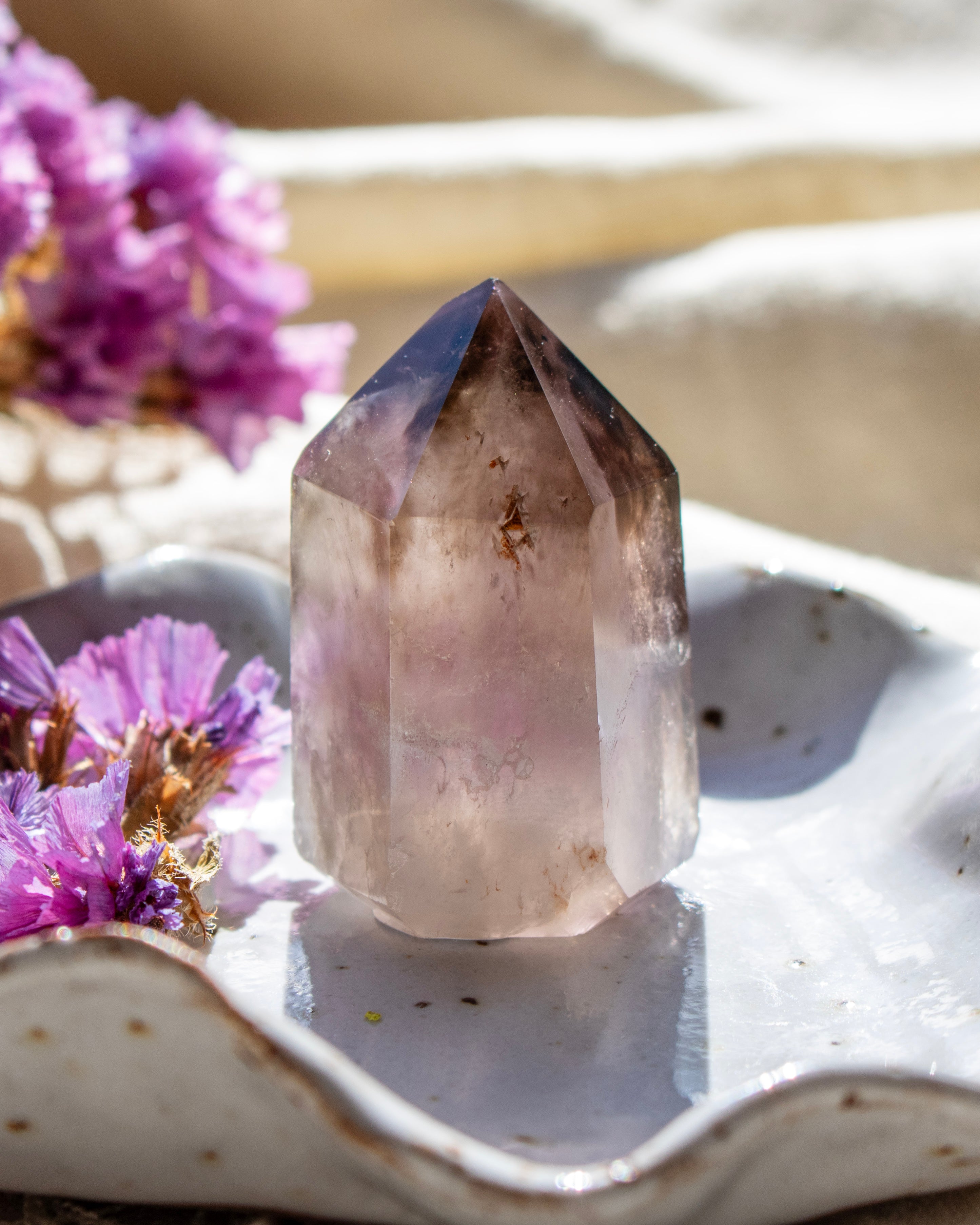 Crystal on a white dish with purple flowers in the background