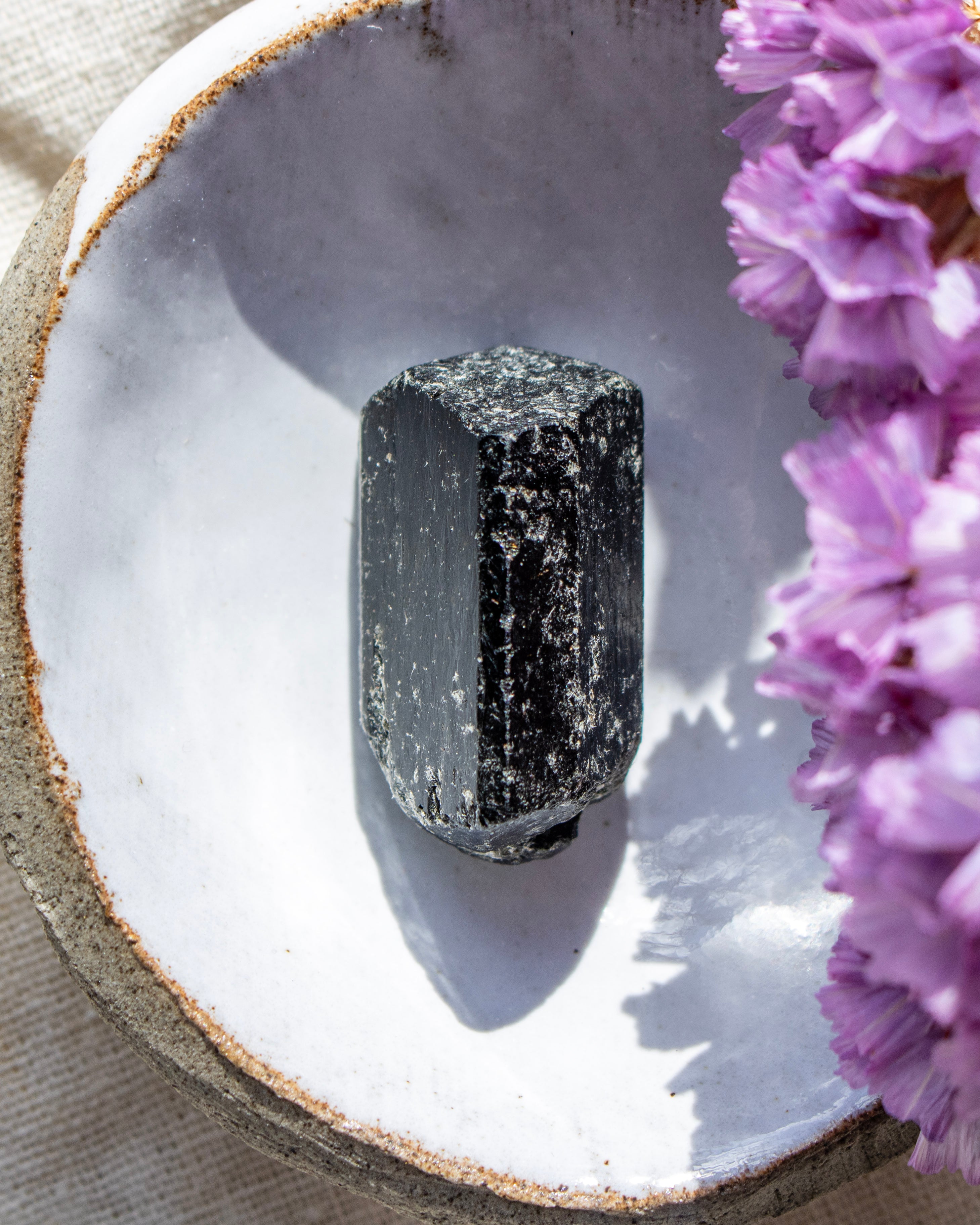 Black stone on a white ceramic dish with pink flowers