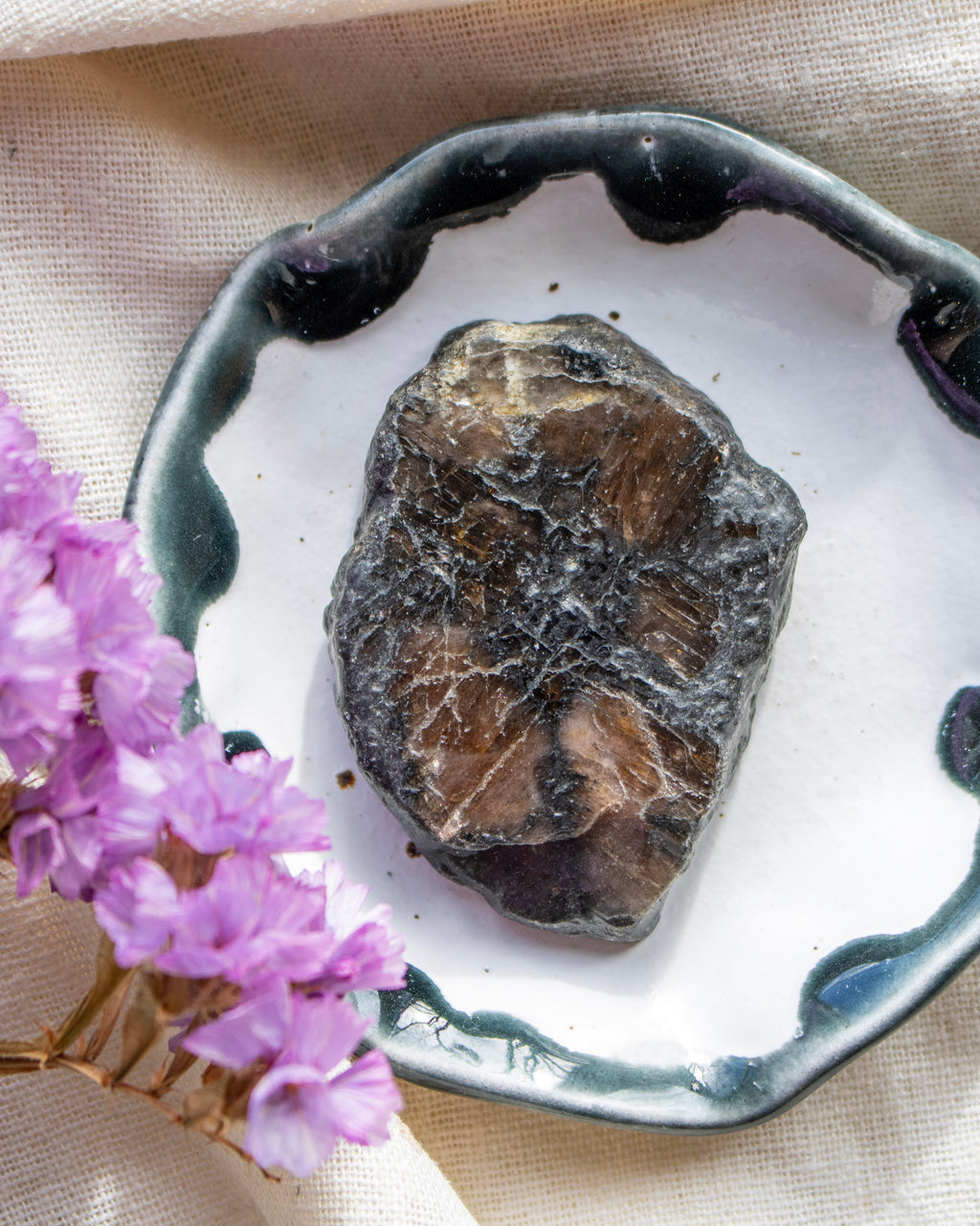 Mineral sample on a decorative plate with purple flowers
