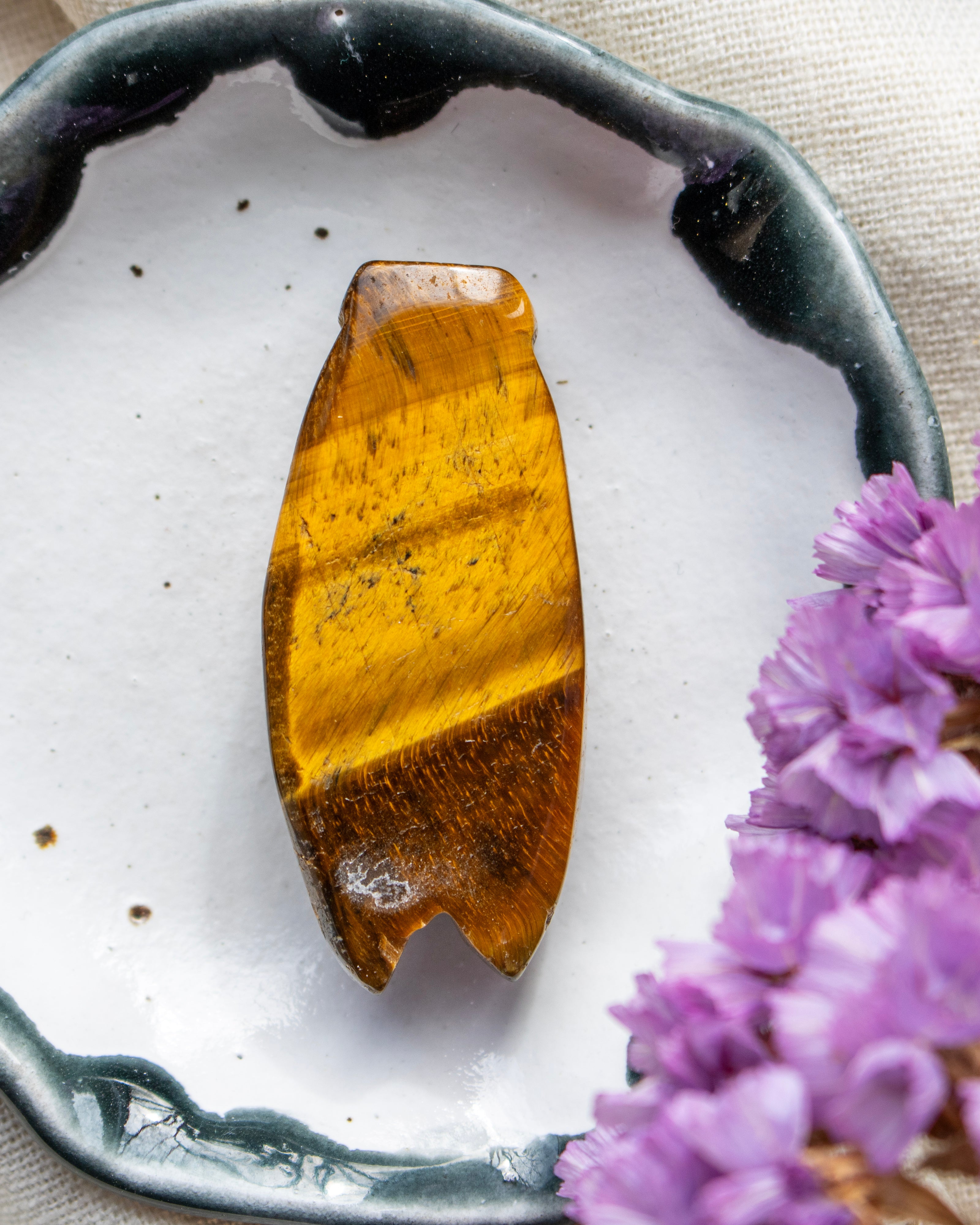 Brown stone on a white plate with purple flowers