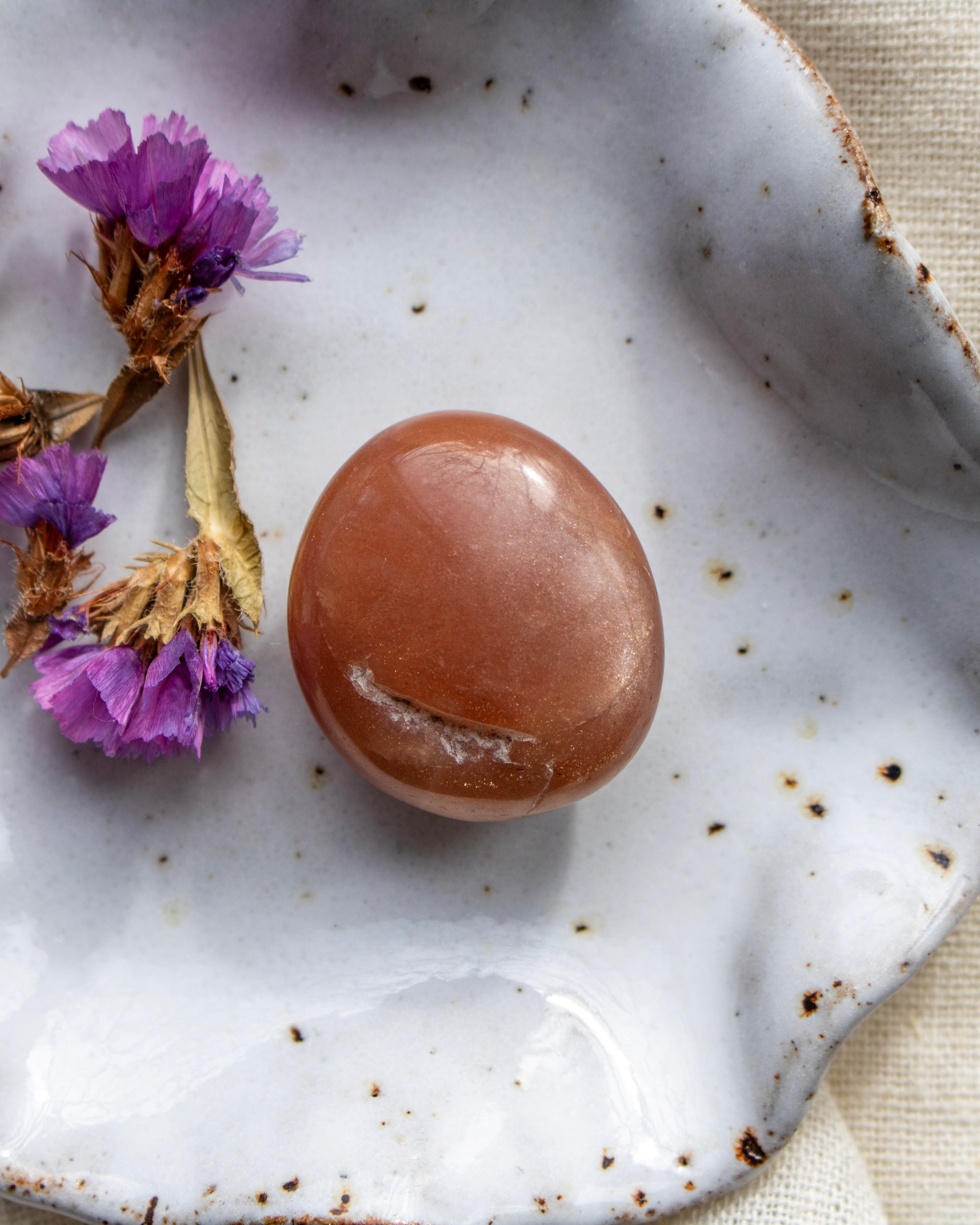 Brown stone on a speckled ceramic plate with purple flowers