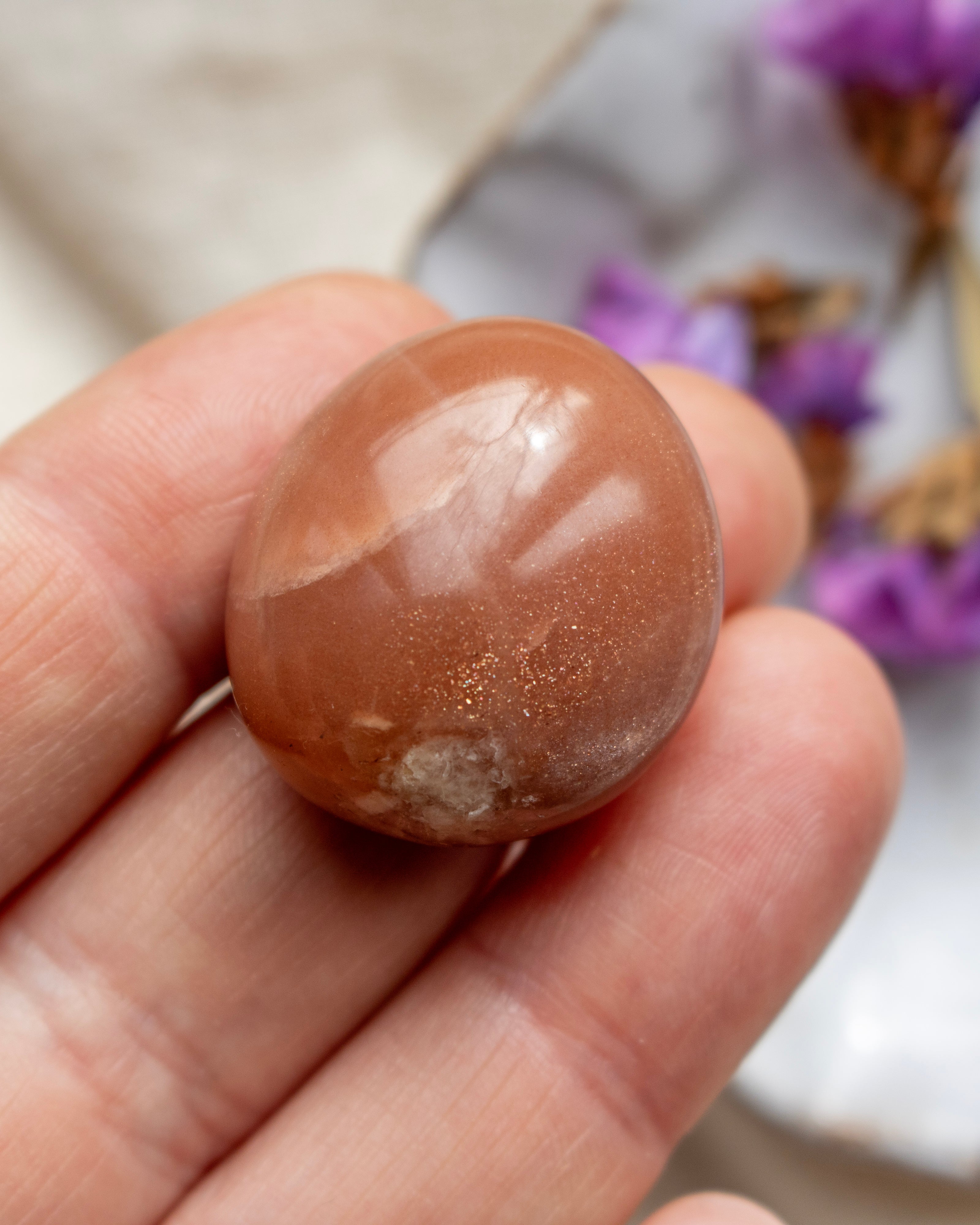 Brown stone held in a hand with a blurred background