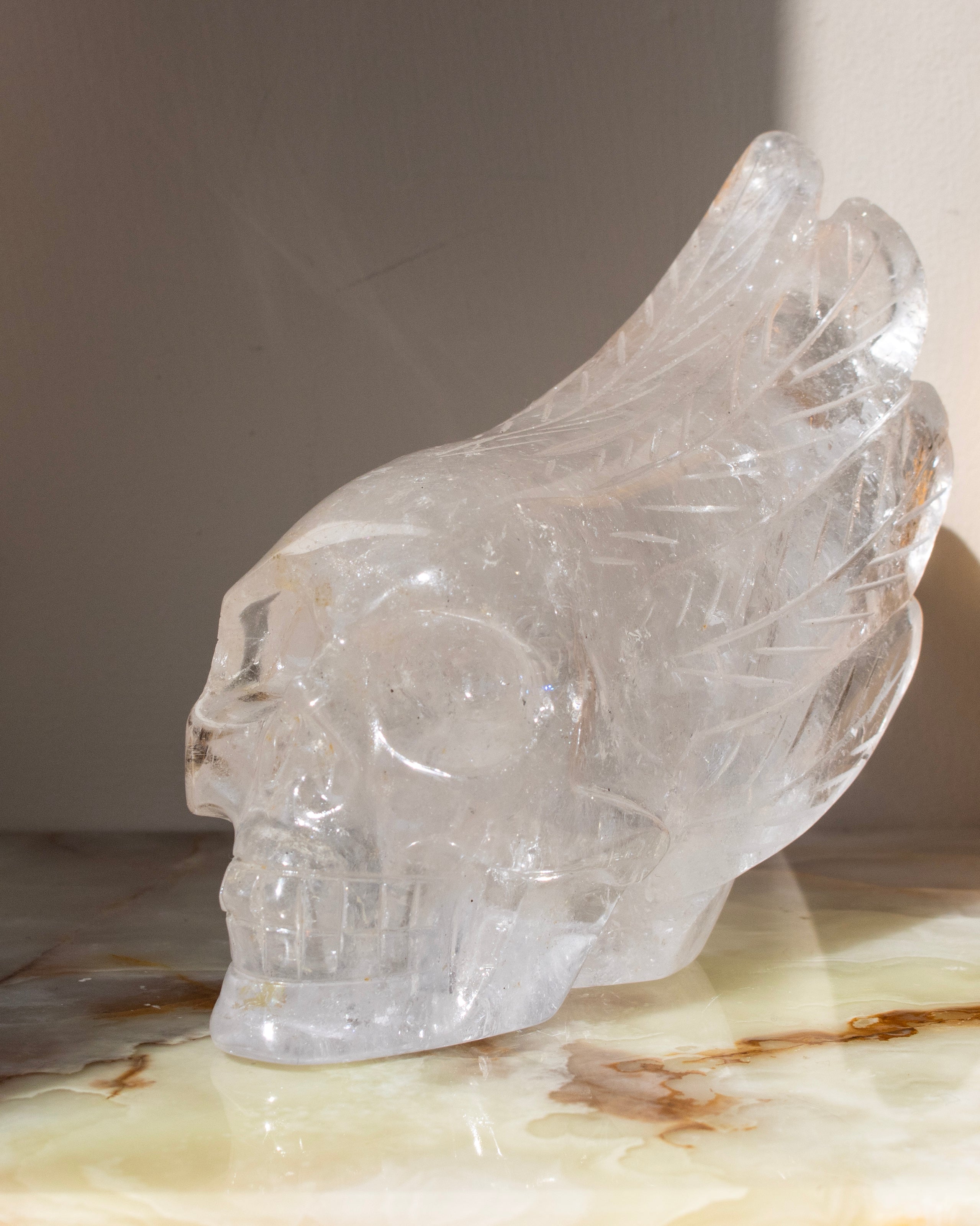 Clear crystal skull on a marble surface with a neutral background