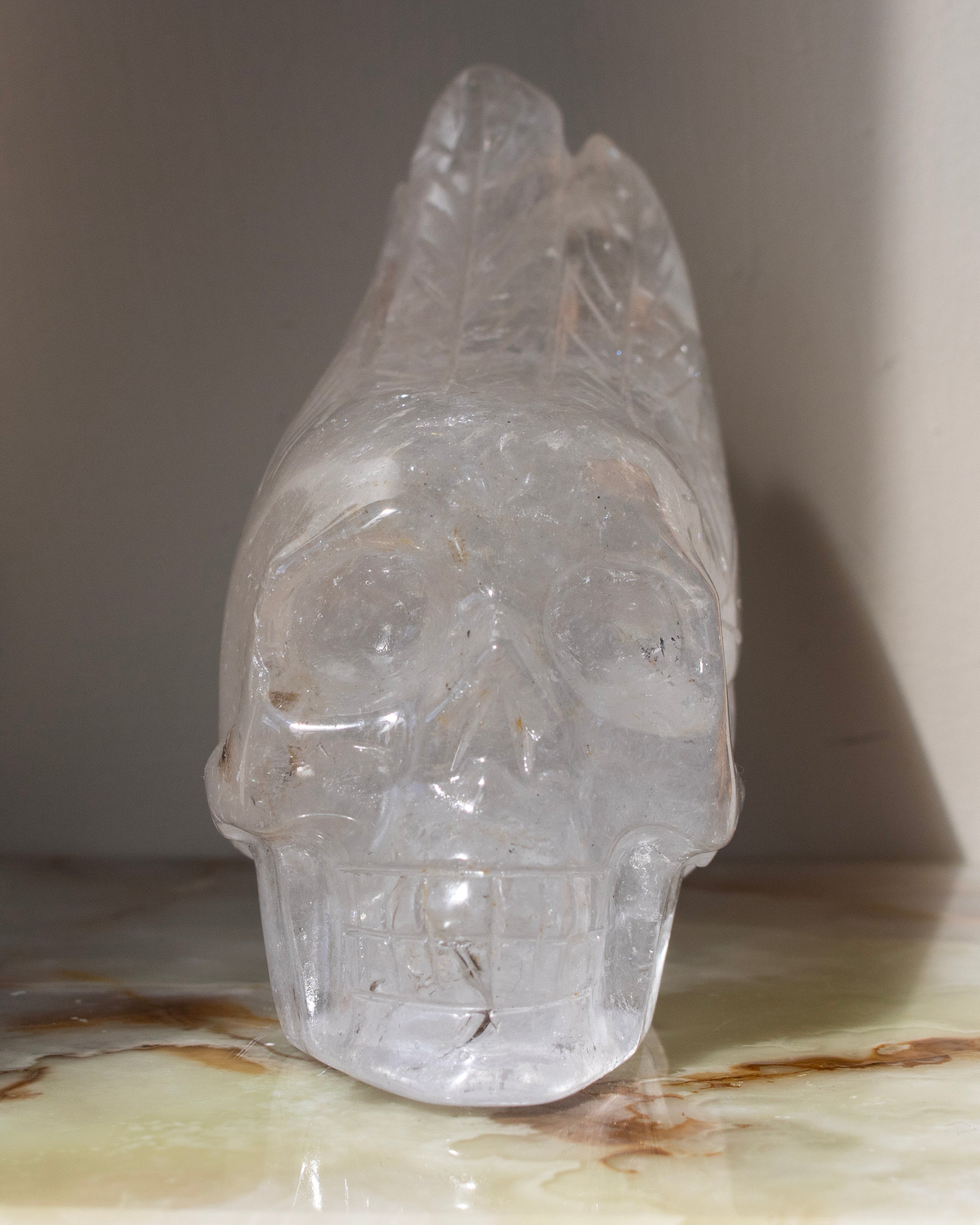 Clear crystal skull on a marble surface with a neutral background
