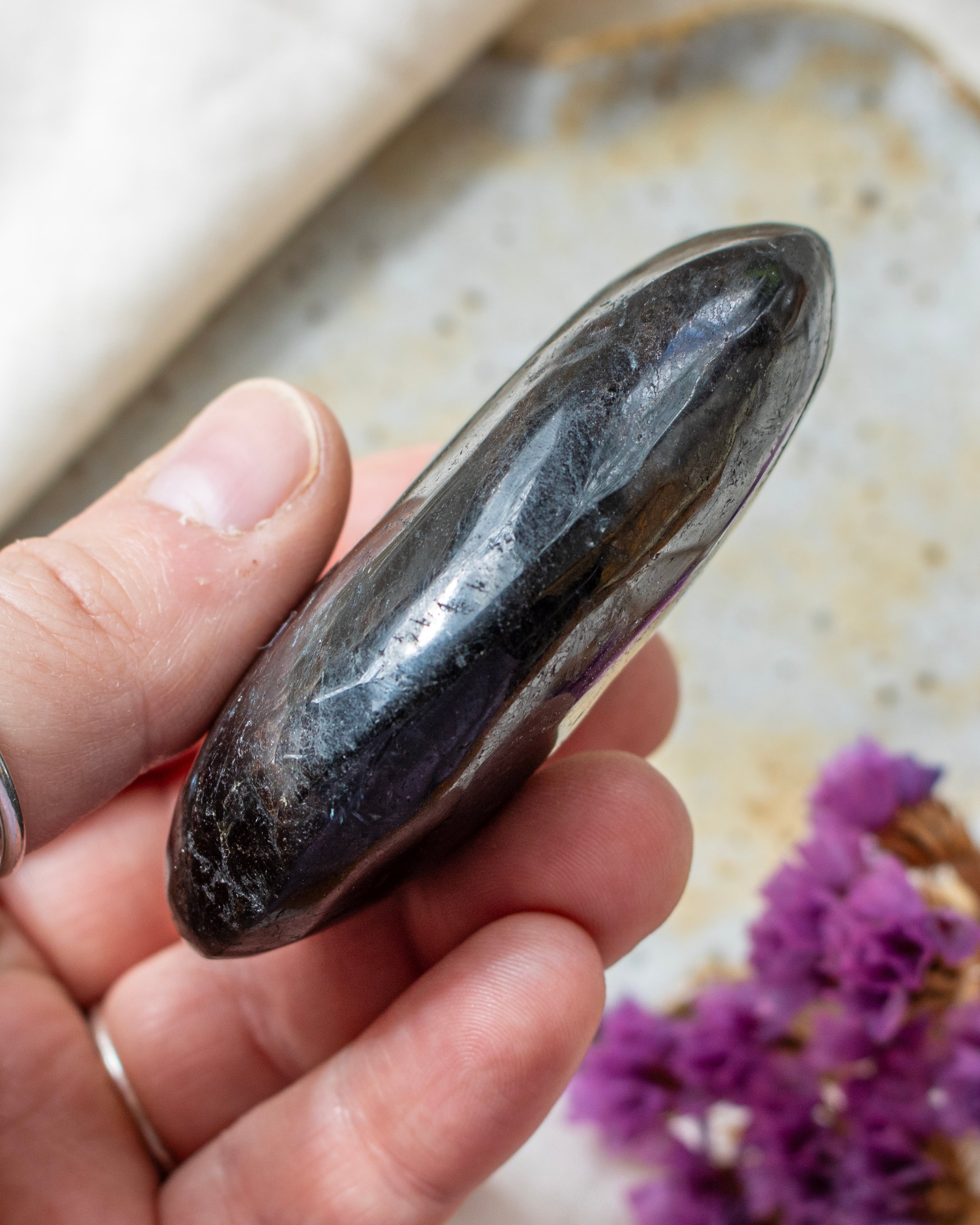 Hand holding a polished stone with a blurred background