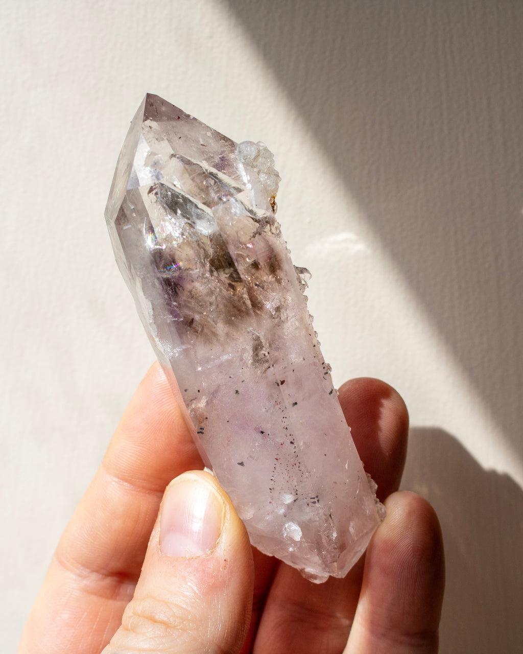 Crystal held in a hand with a neutral background