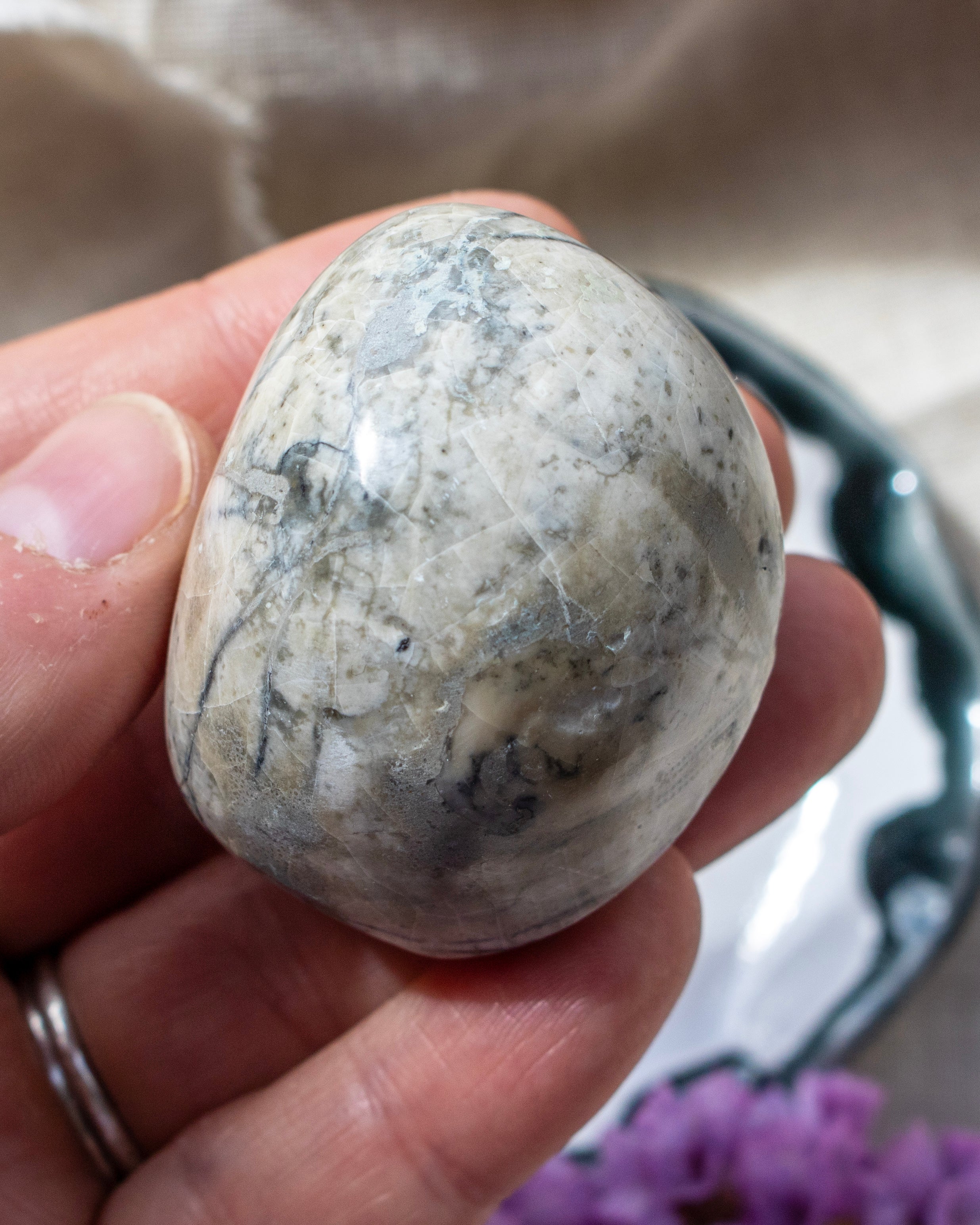 Hand holding a marbled stone with a blurred background