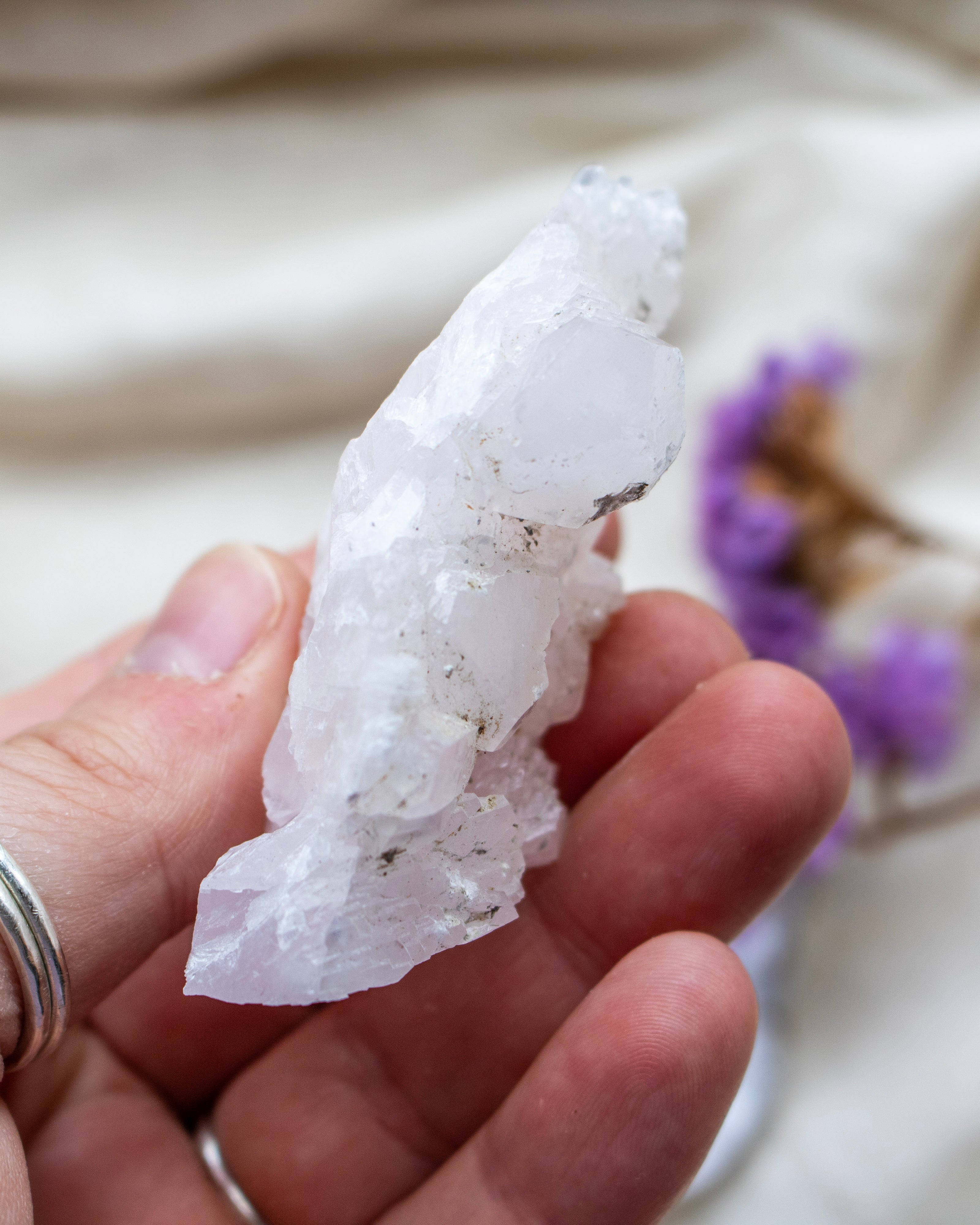 Hand holding a crystal with a blurred background
