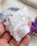 Hand holding a large crystal rock with a blurred background