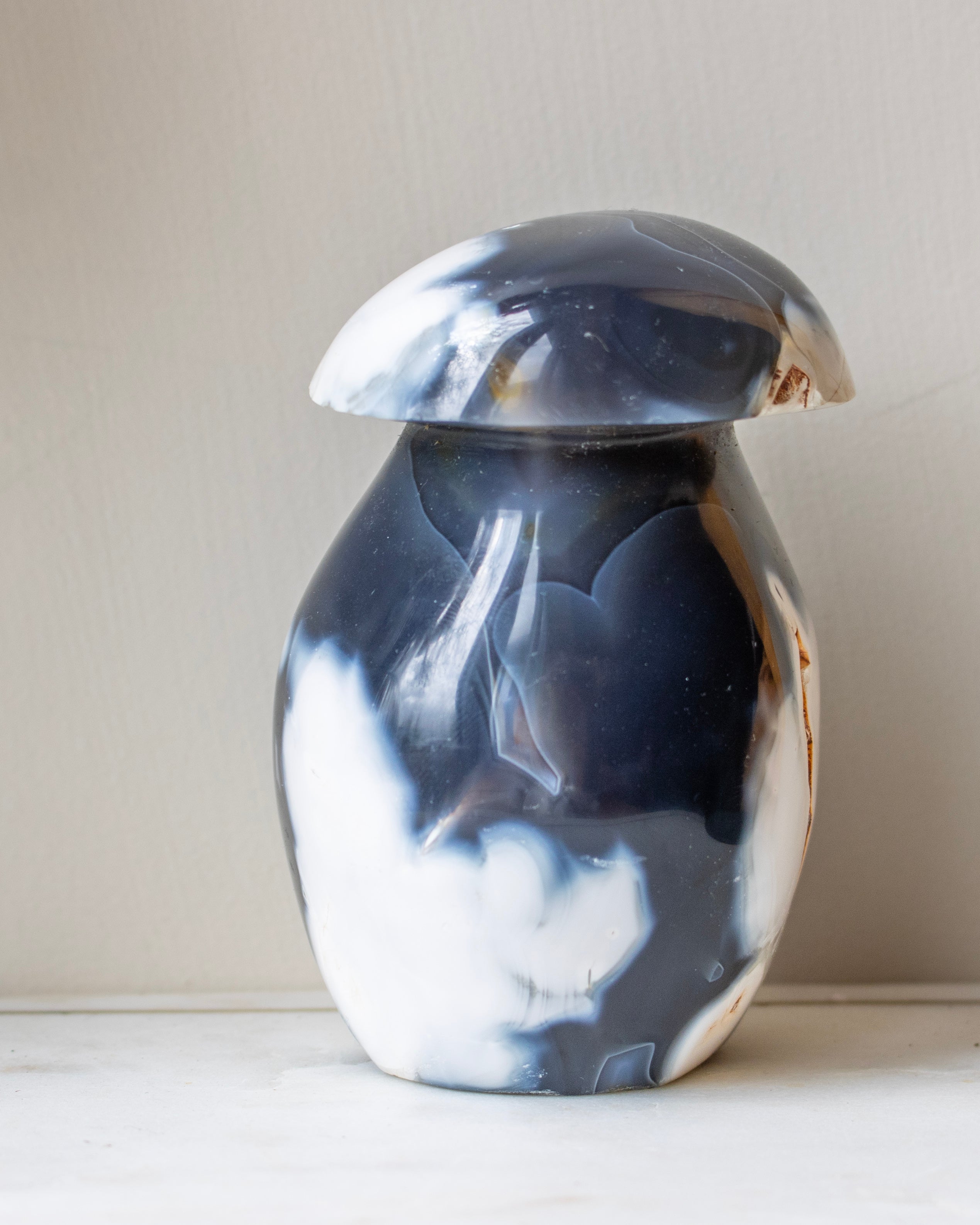 Marble-patterned agate on a white surface against a beige background