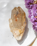 Clear crystal on a white surface with purple flowers
