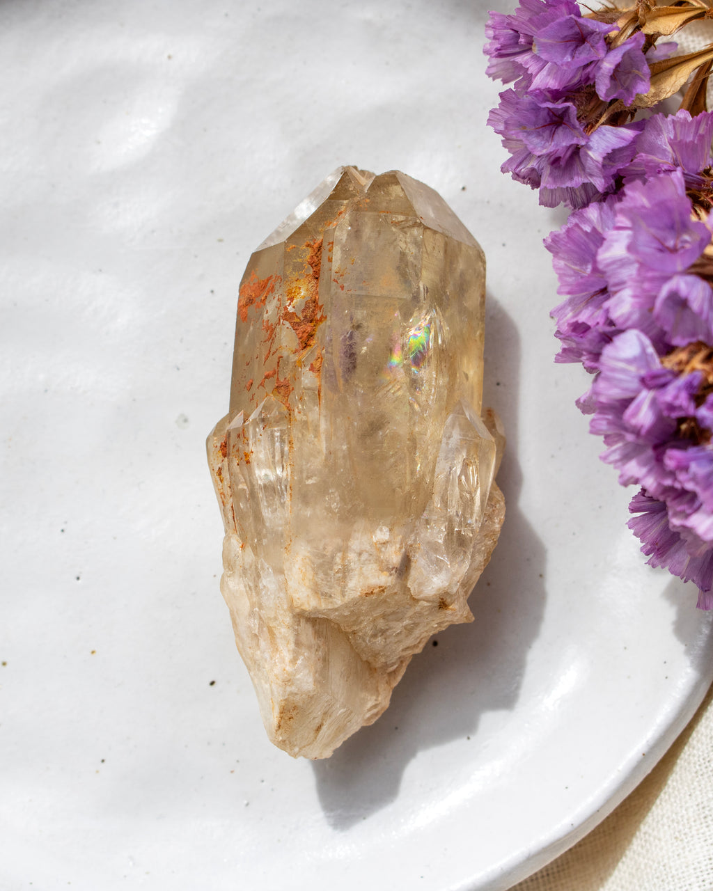 Crystal on a white plate with purple flowers