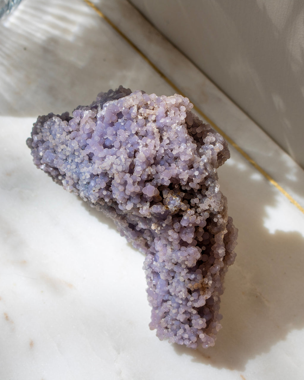 Purple crystal rock on a light surface