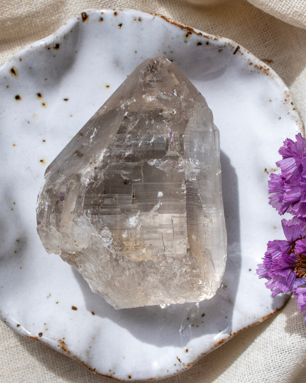 Crystal on a white ceramic plate with purple flowers