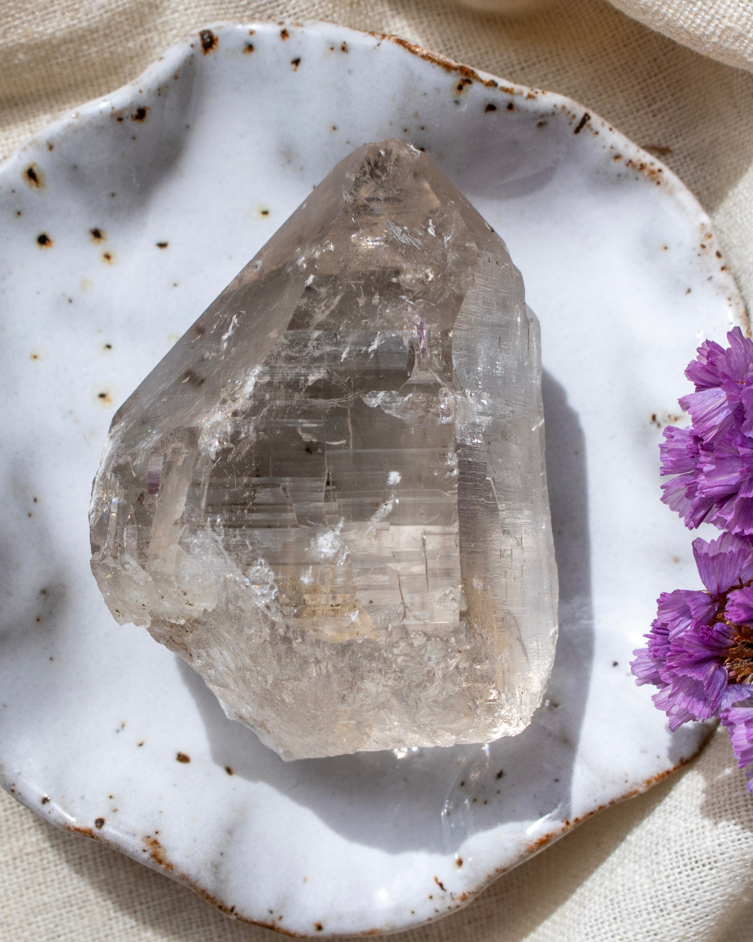 Crystal on a white ceramic plate with purple flowers