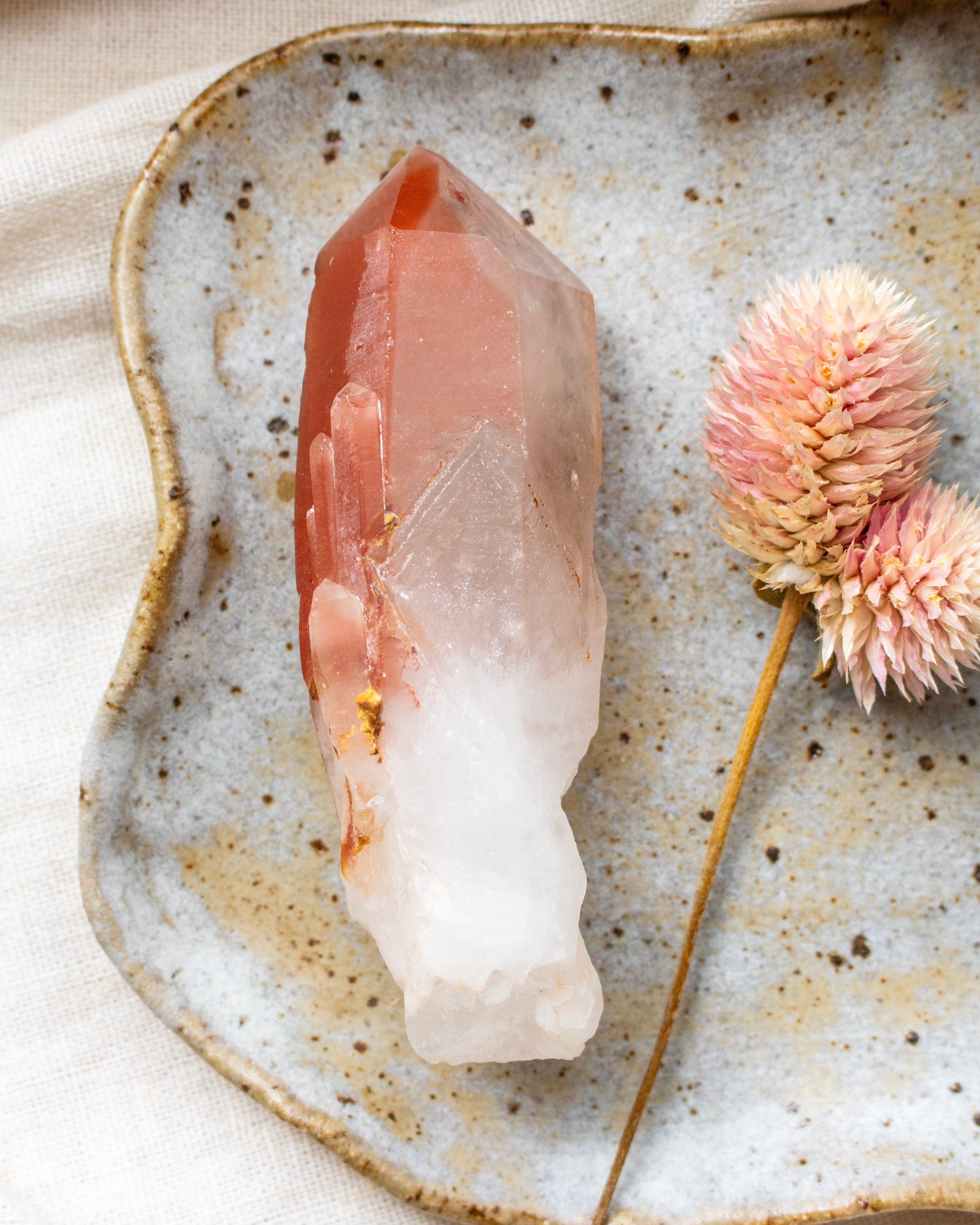 Crystal on a textured ceramic plate with a pink flower
