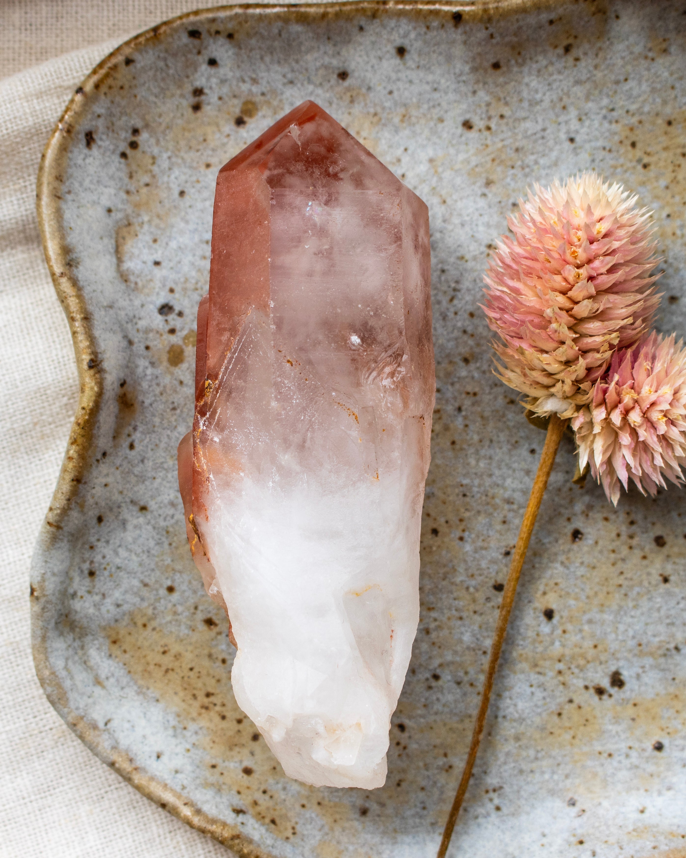 Crystal on a textured ceramic plate with dried flowers