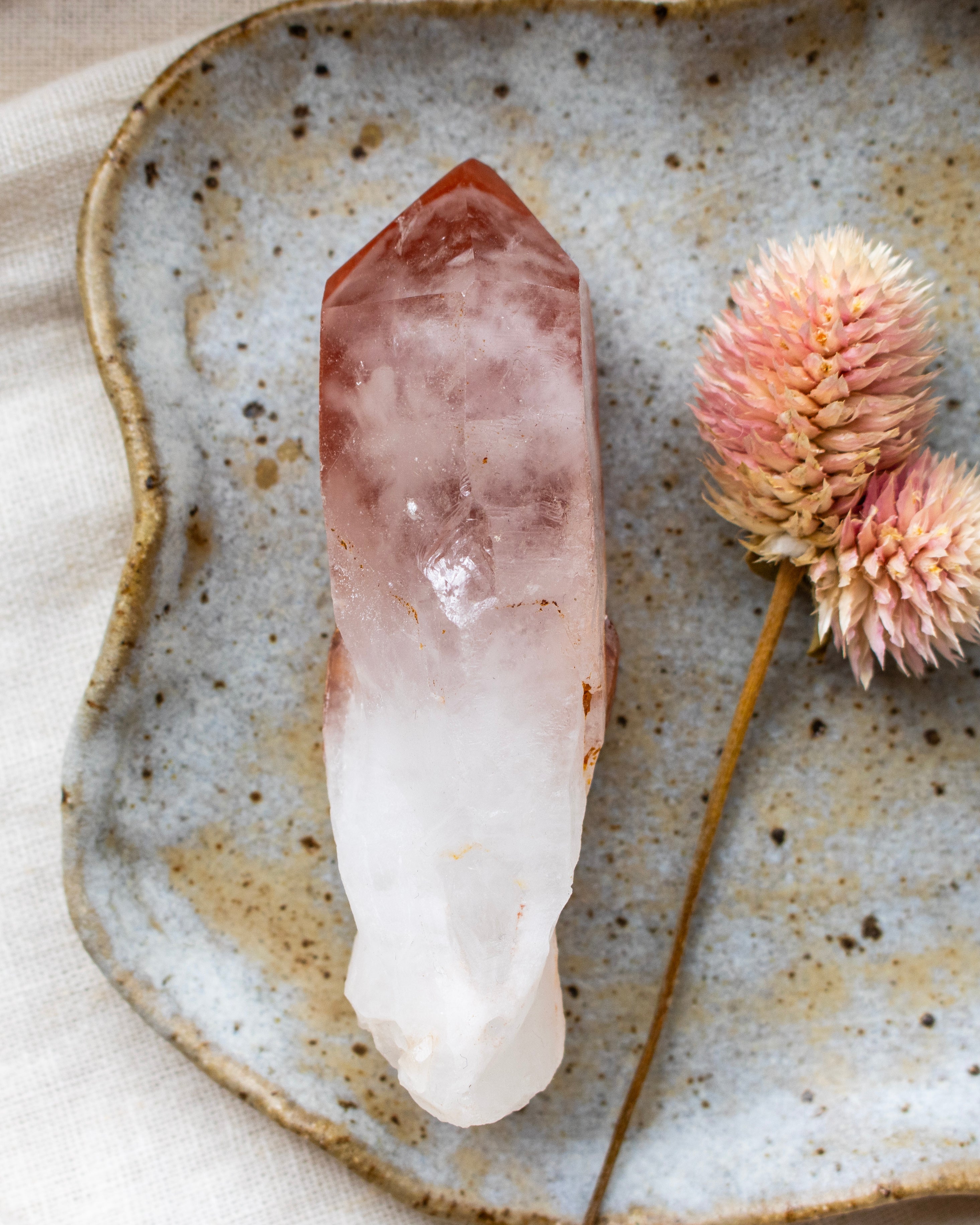 Crystal on a textured ceramic plate with dried flowers