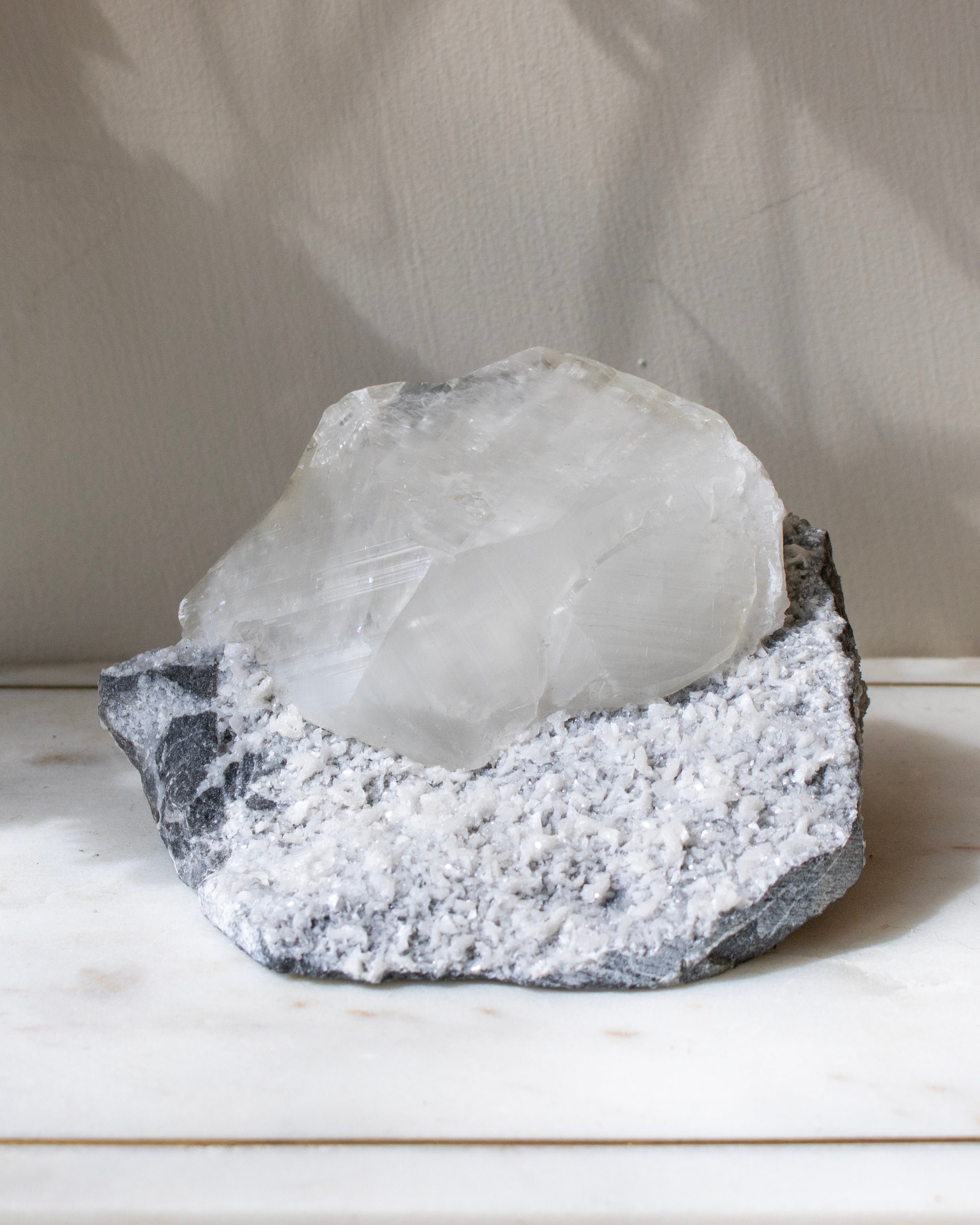 A large cystallised rock specimen with a neutral background