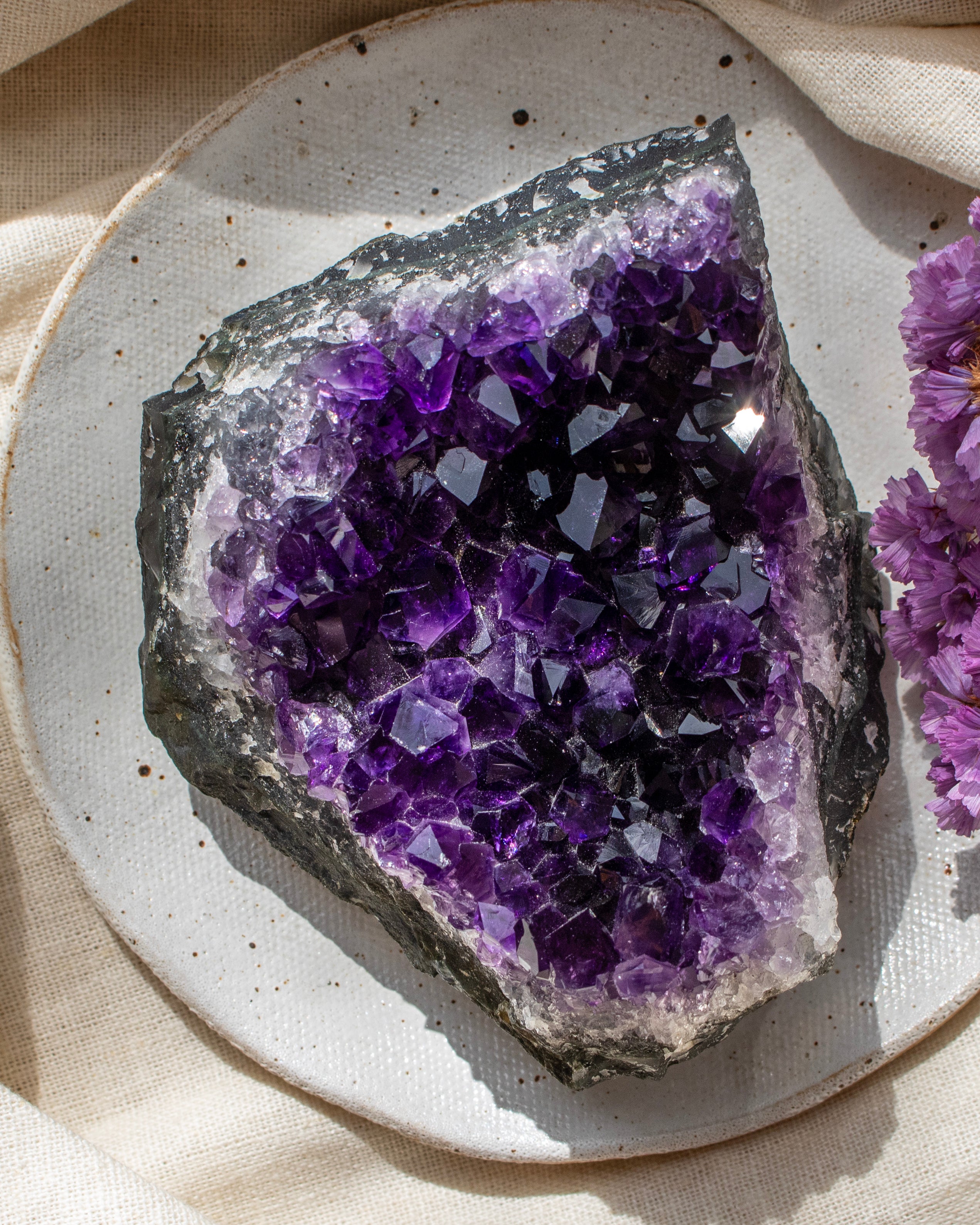Amethyst crystal on a textured surface with a soft background