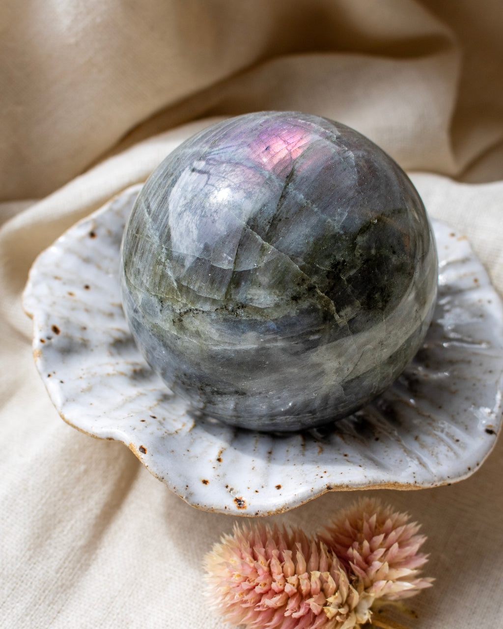 Crystal ball on a shell with a beige fabric background