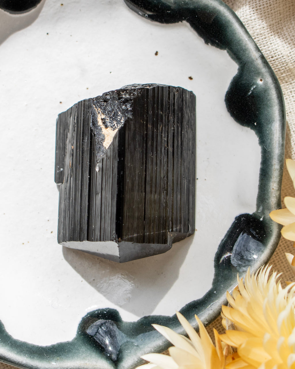 Black crystal on a white surface with a decorative handle