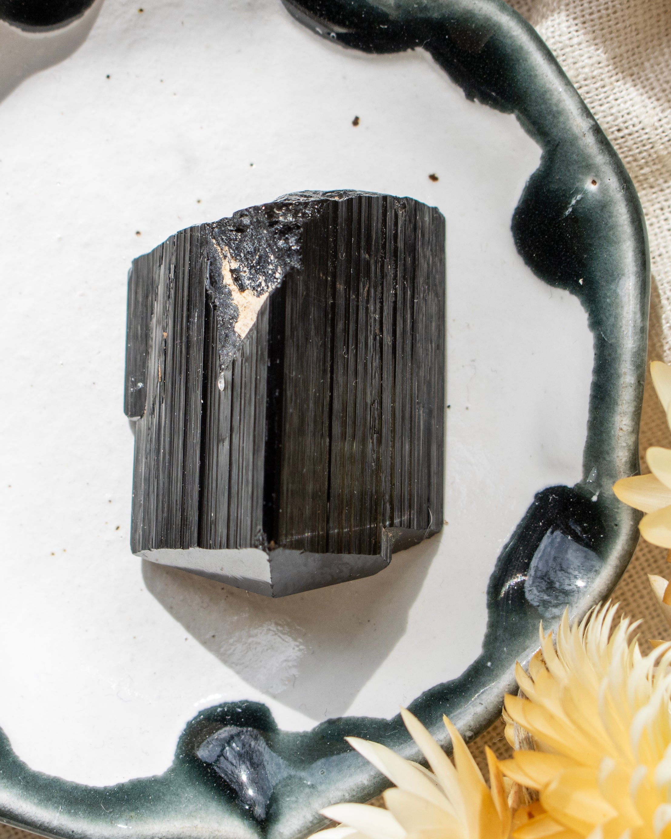 Black crystal on a white surface with a decorative handle