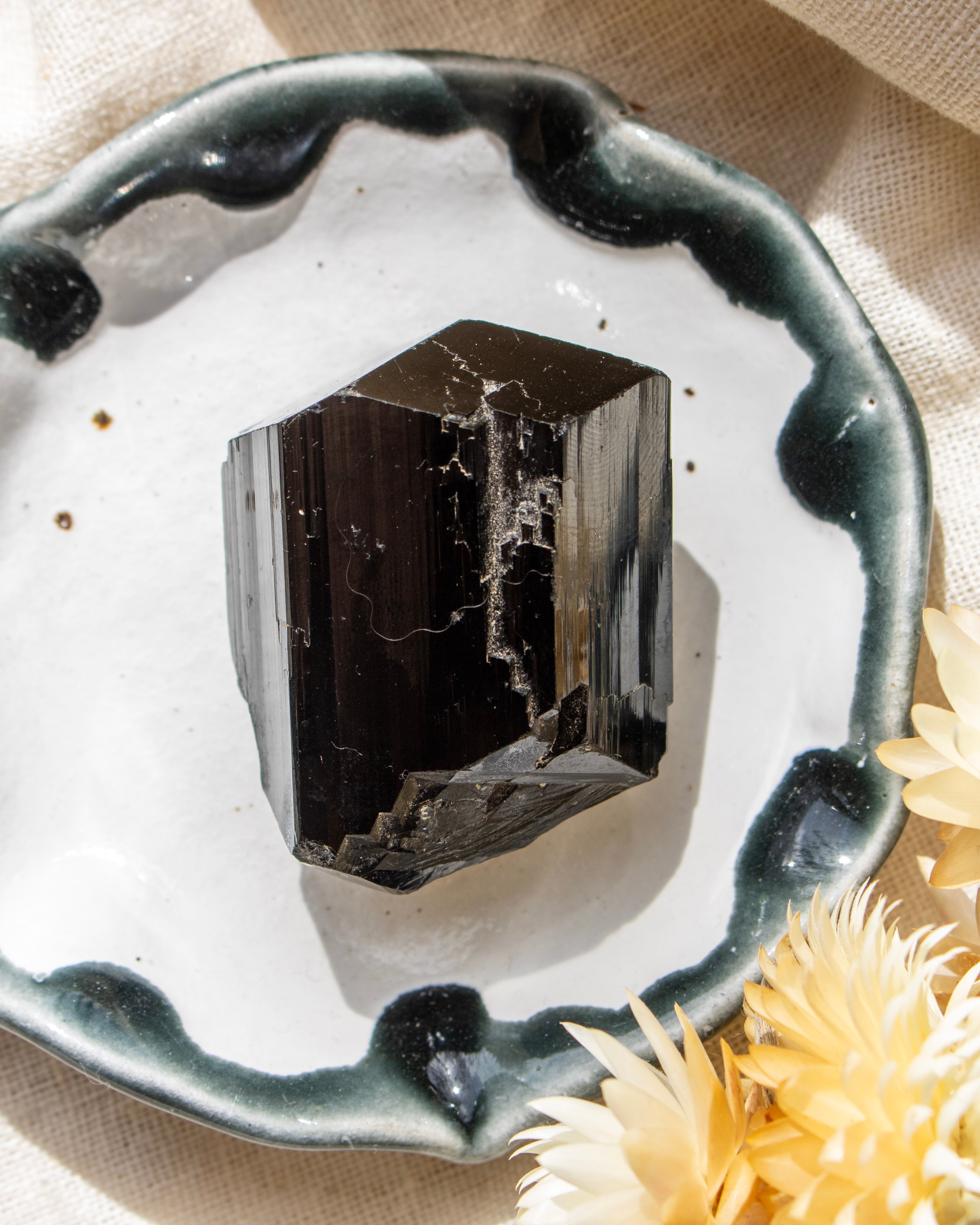Mineral crystal on a decorative ceramic plate with dried flowers