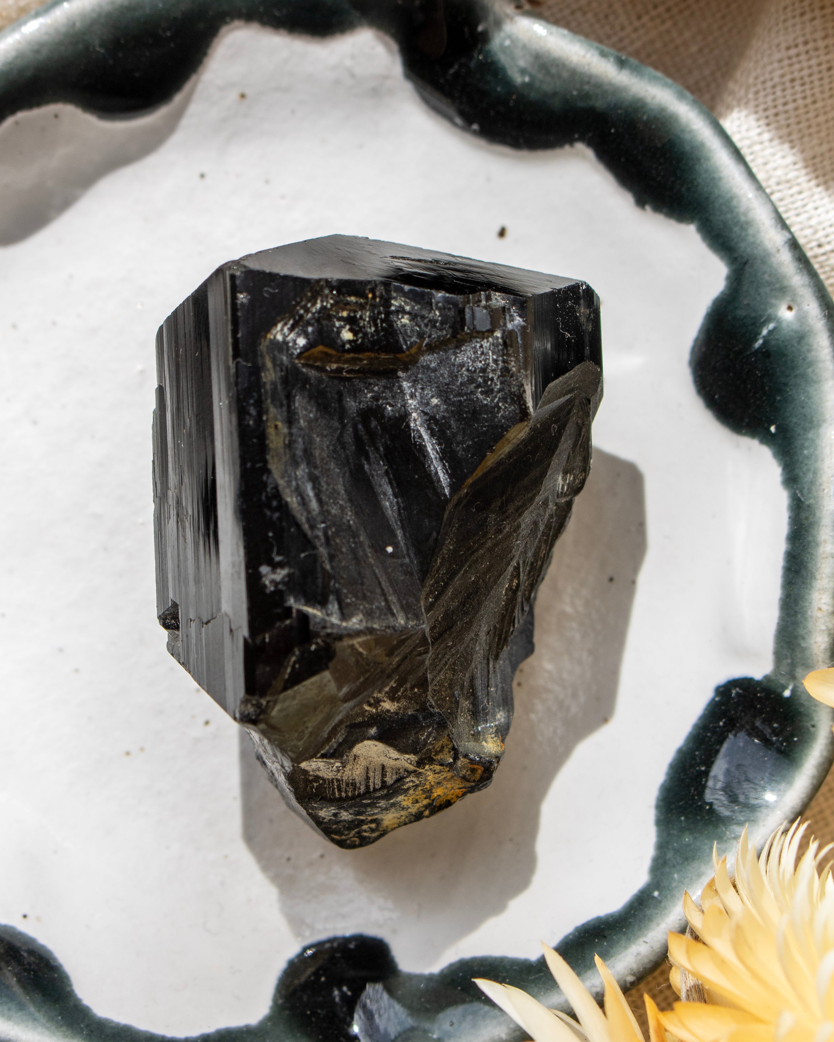 Black crystal on a white surface with a decorative black holder