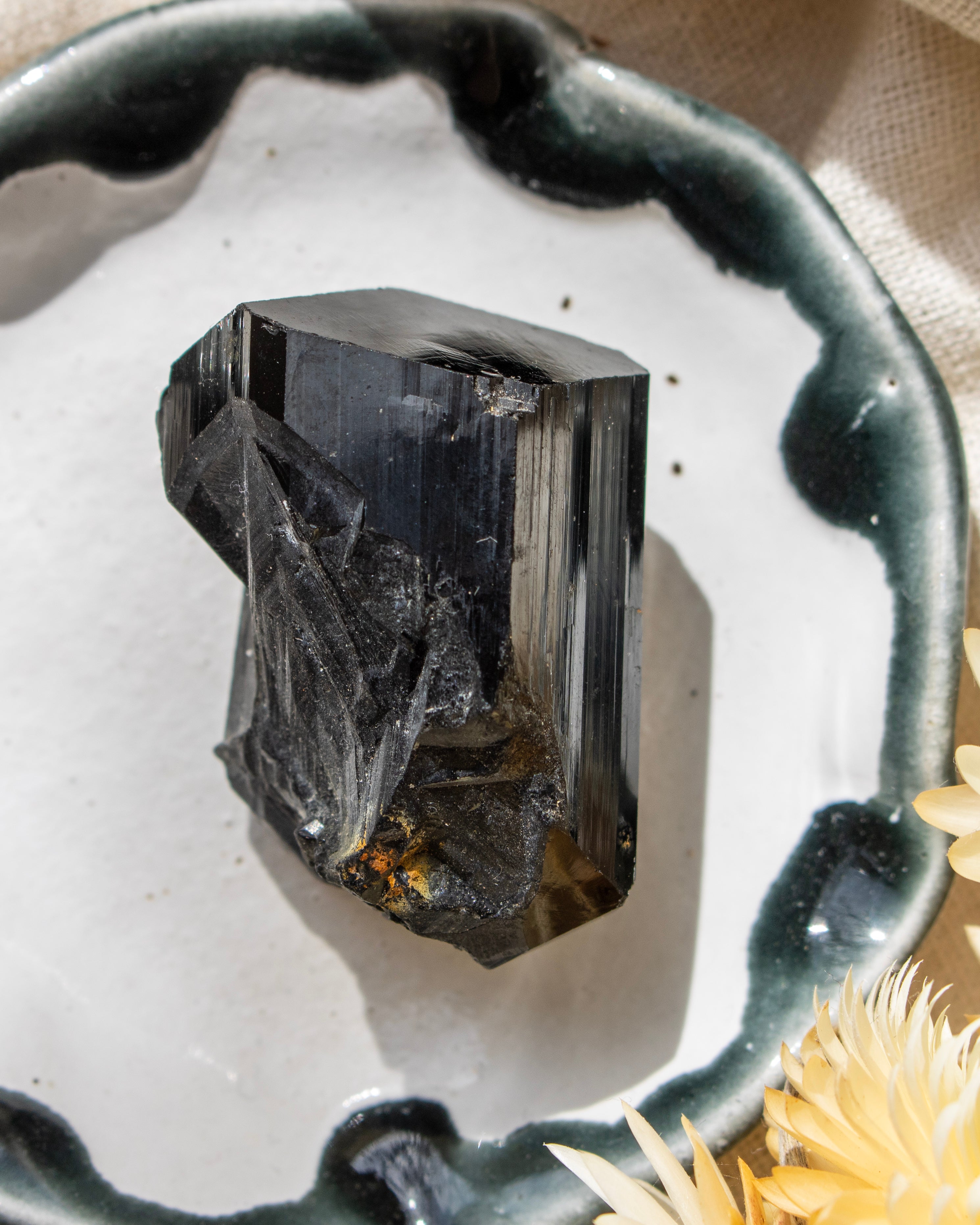 Black crystal on a white surface with a decorative edge