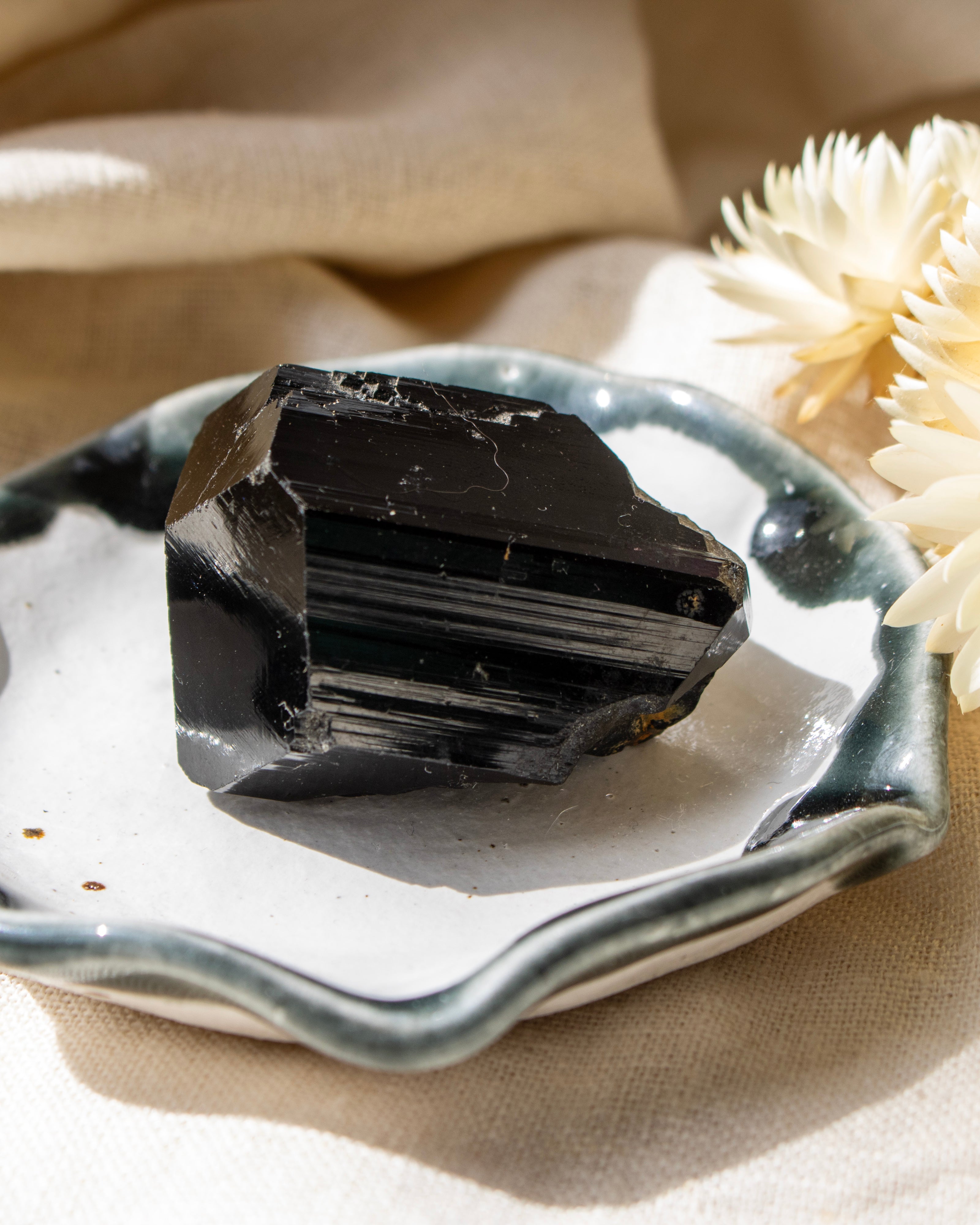 Black crystal on a white plate with beige background