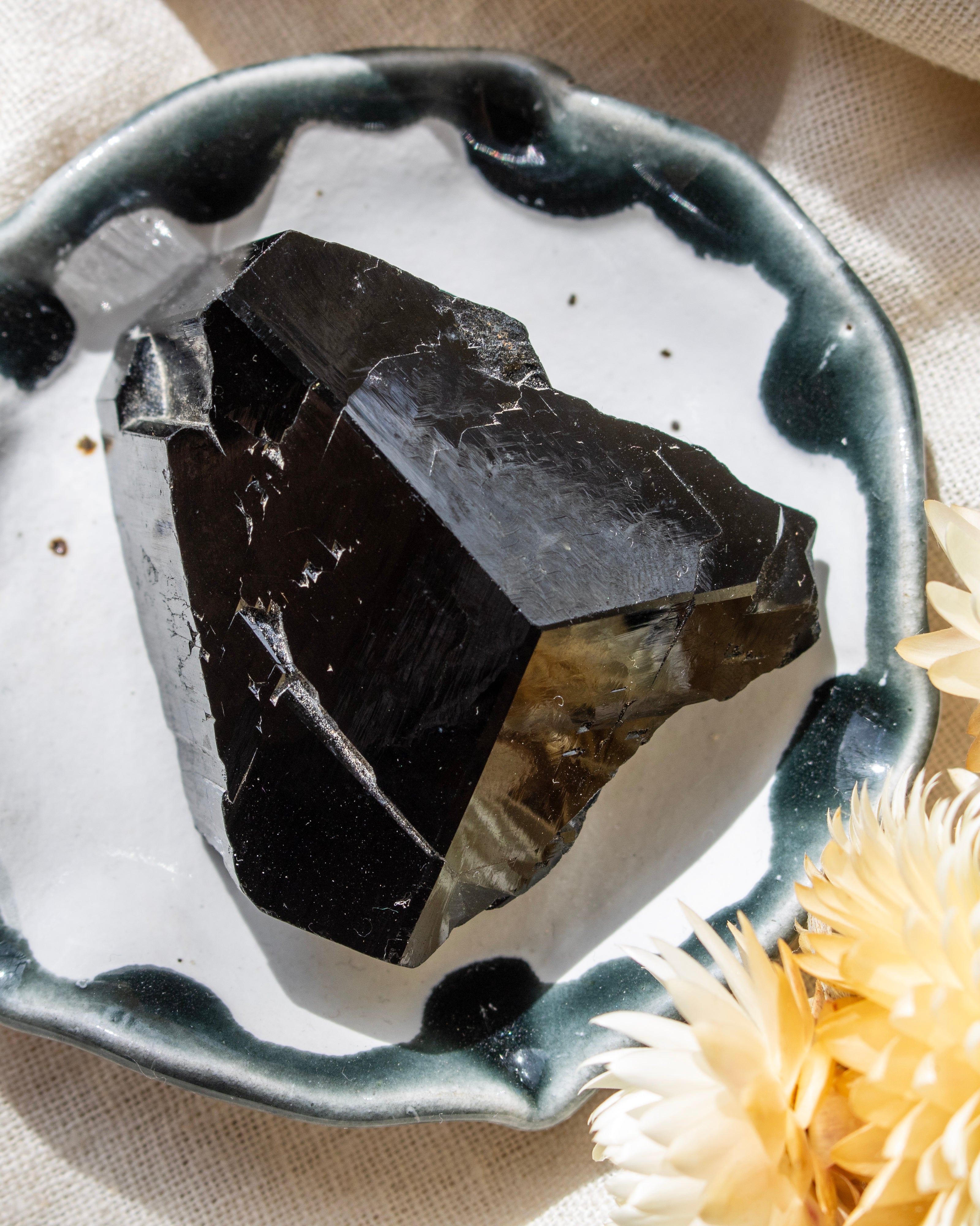 Black crystal in a decorative dish with a beige background