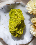 Green stone on a white ceramic plate with yellow flowers