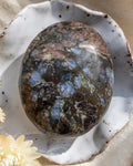 Polished stone with blue and brown patterns on a textured surface