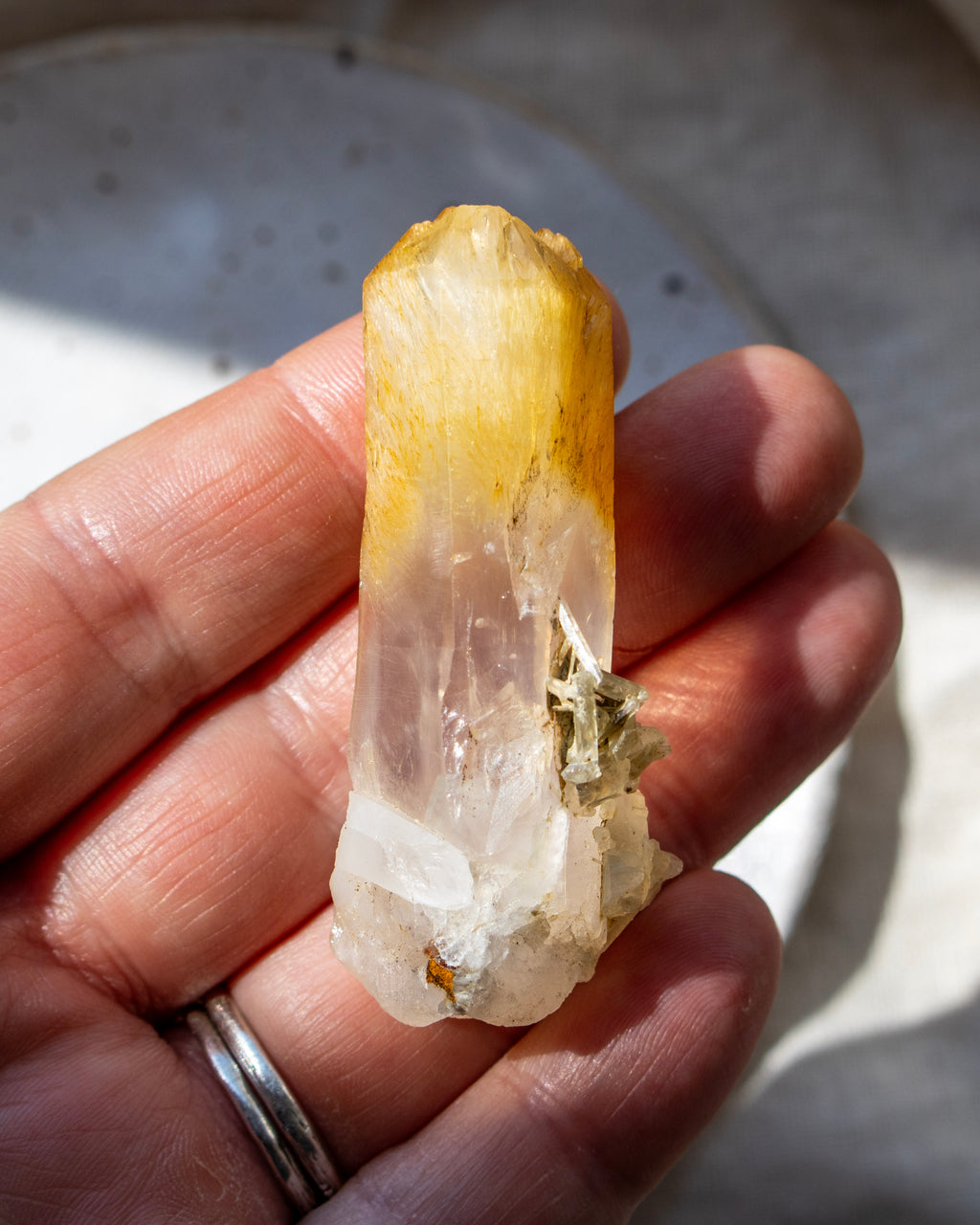 Hand holding a crystal with a blurred background