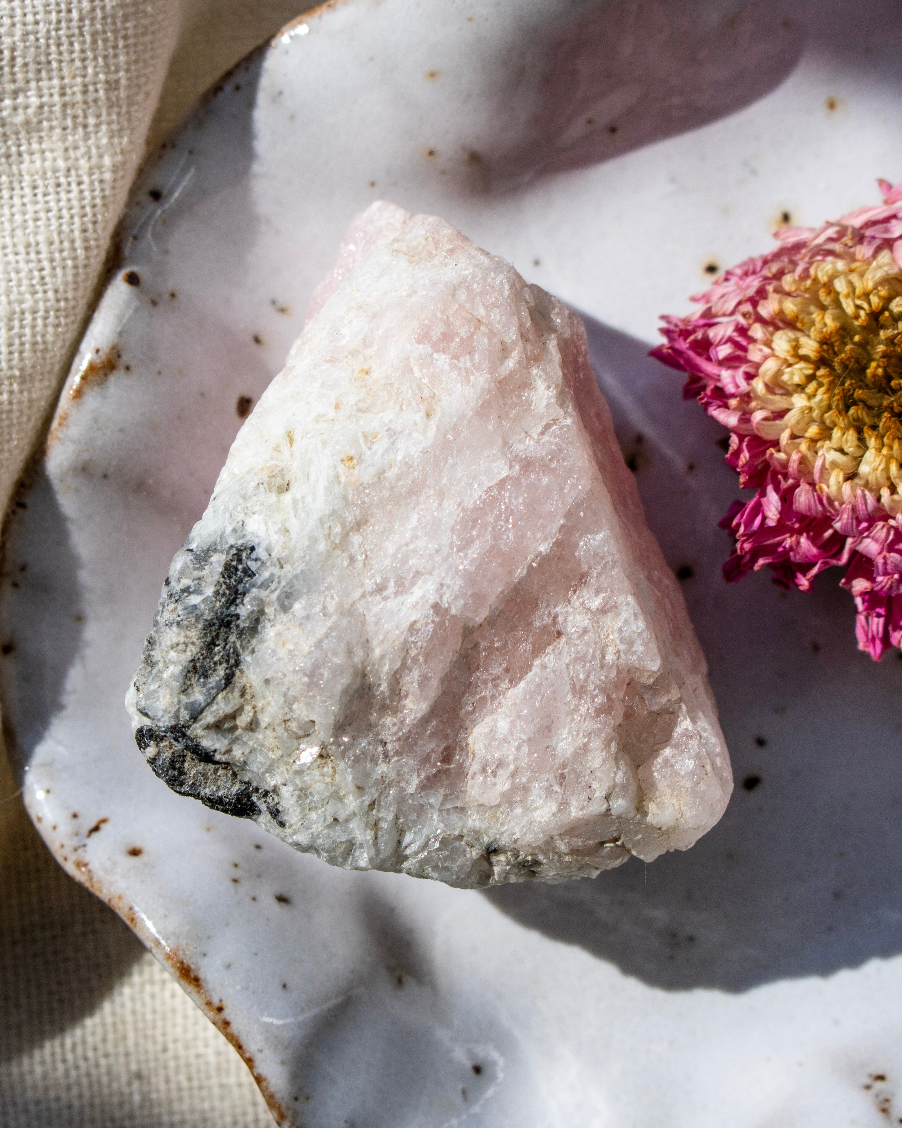 Crystal rock on a textured ceramic plate with a pink flower