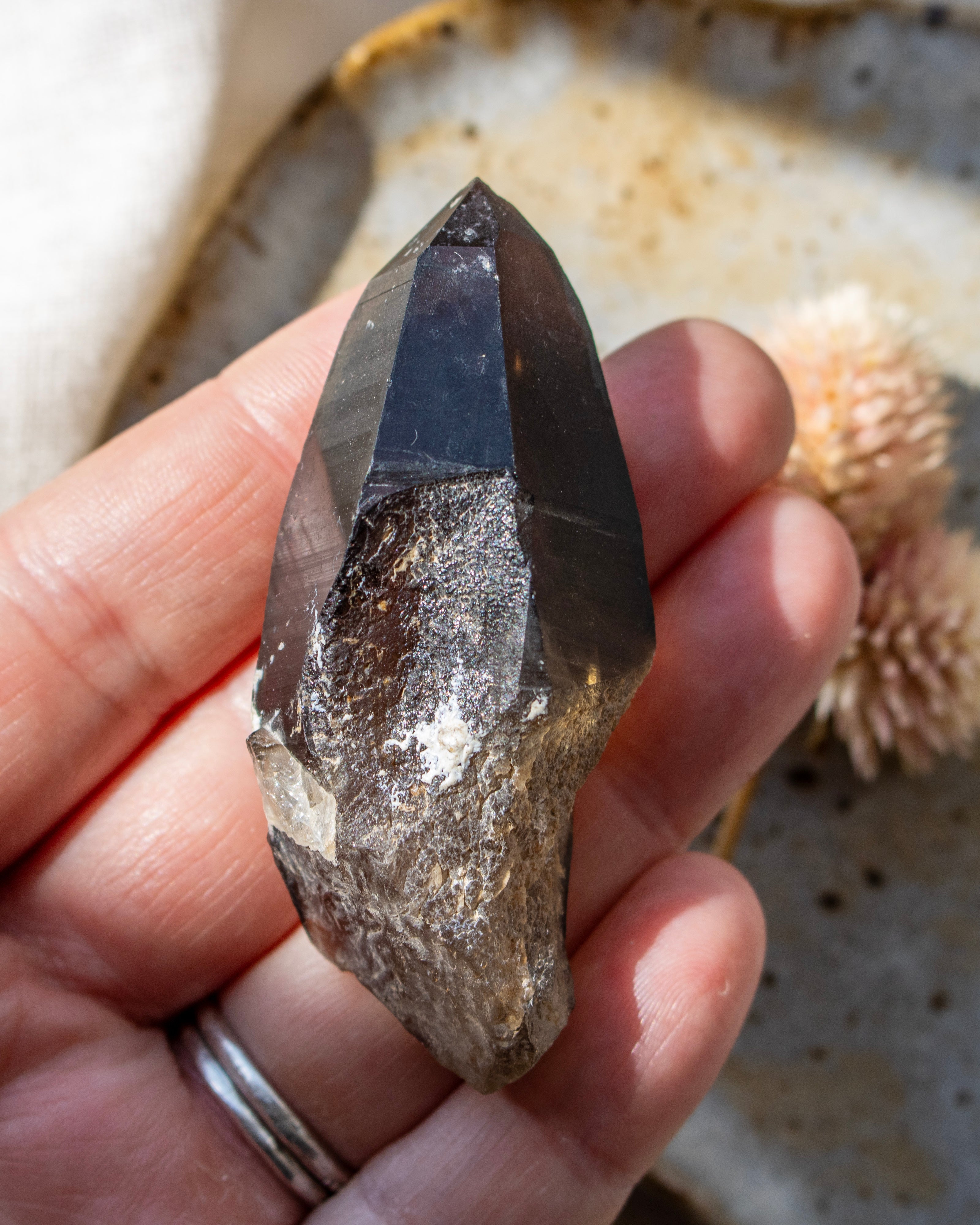Hand holding a crystal with a natural background