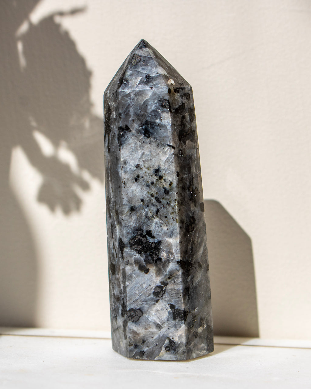 Decorative crystal tower on a light surface with a neutral background