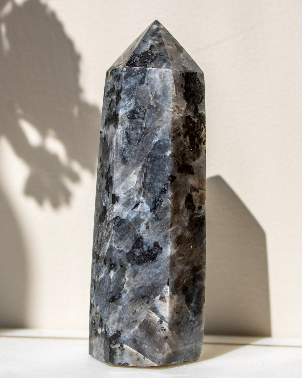 Decorative crystal tower on a white surface with a neutral background