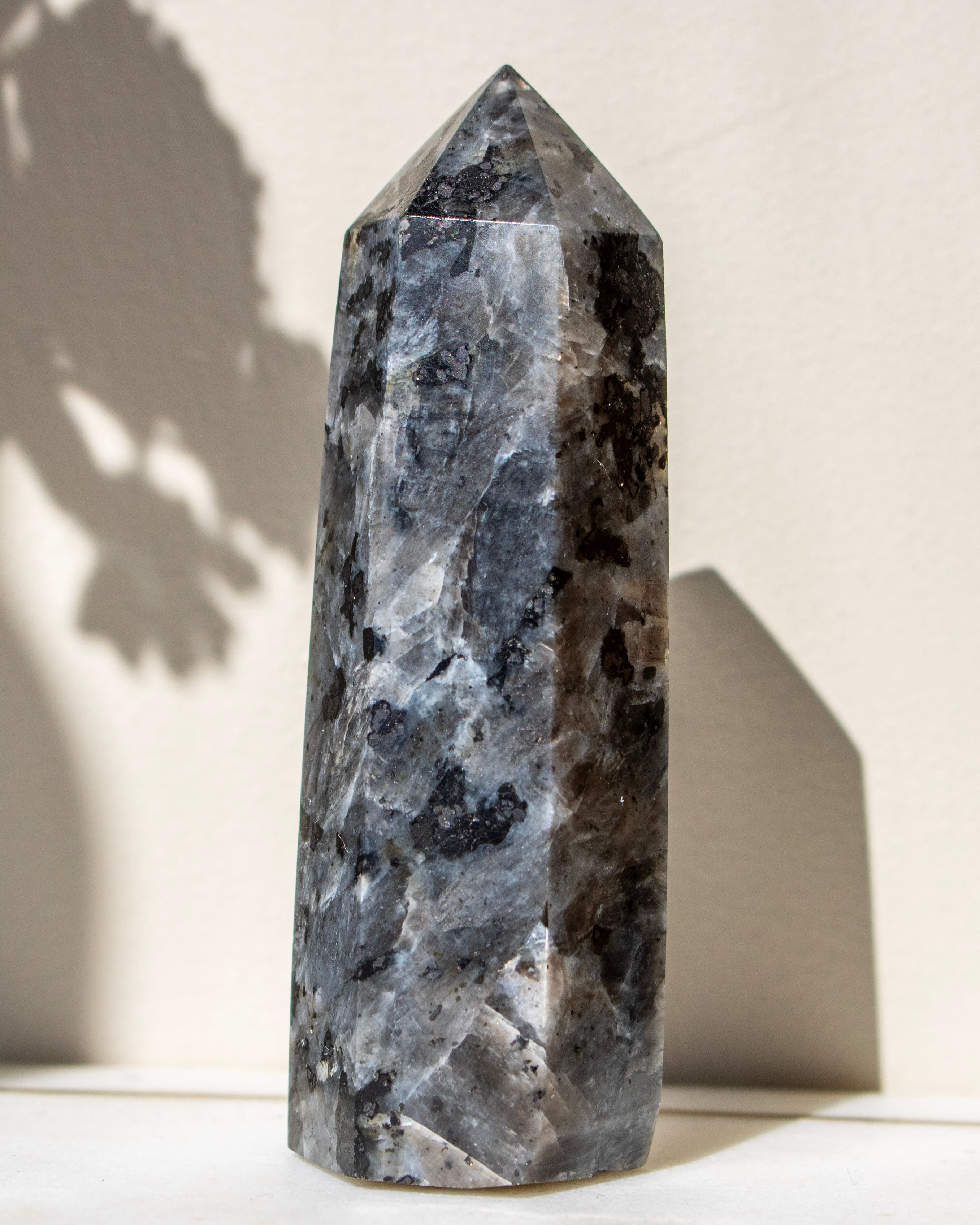 Decorative crystal tower on a white surface with a neutral background