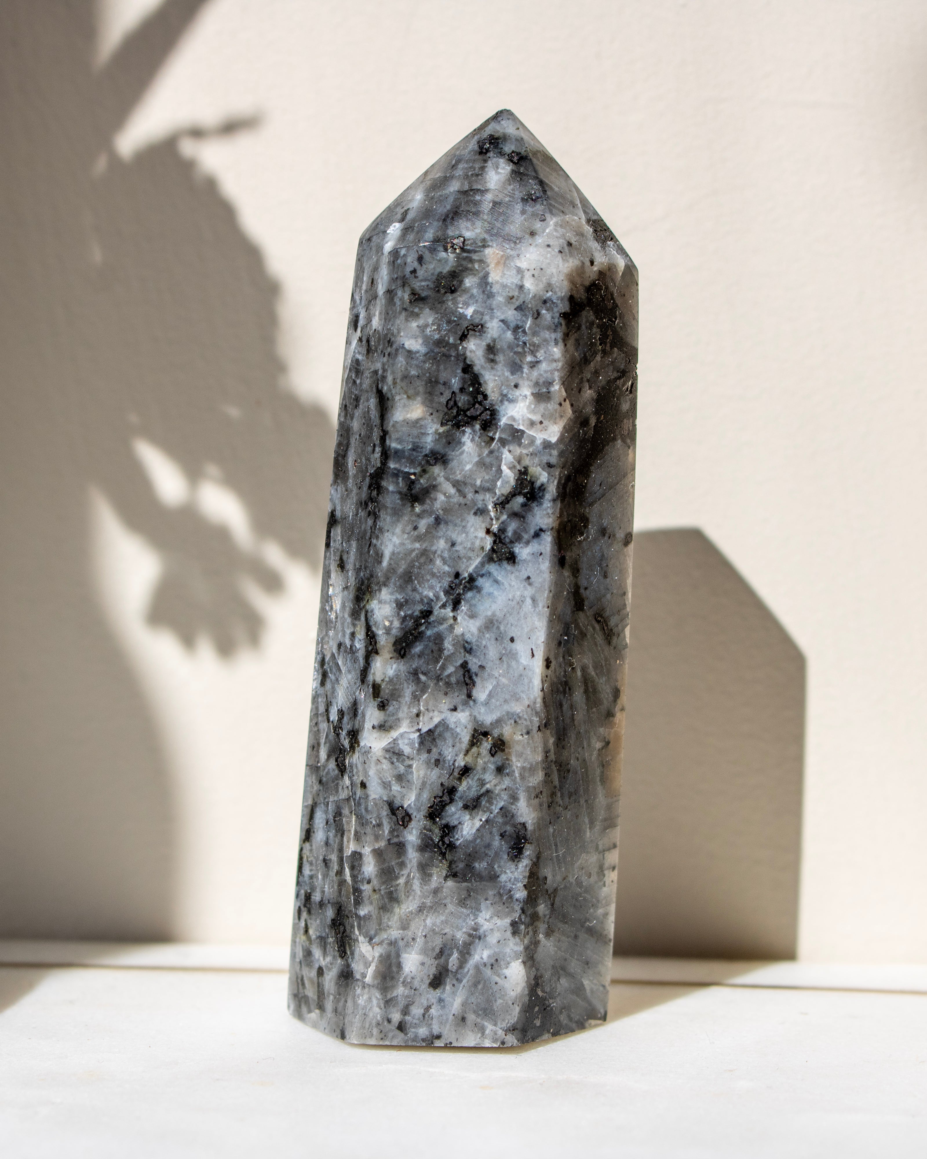 Gray crystal tower on a white surface with a neutral background