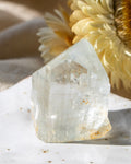 Clear crystal on a textured surface with a blurred natural background