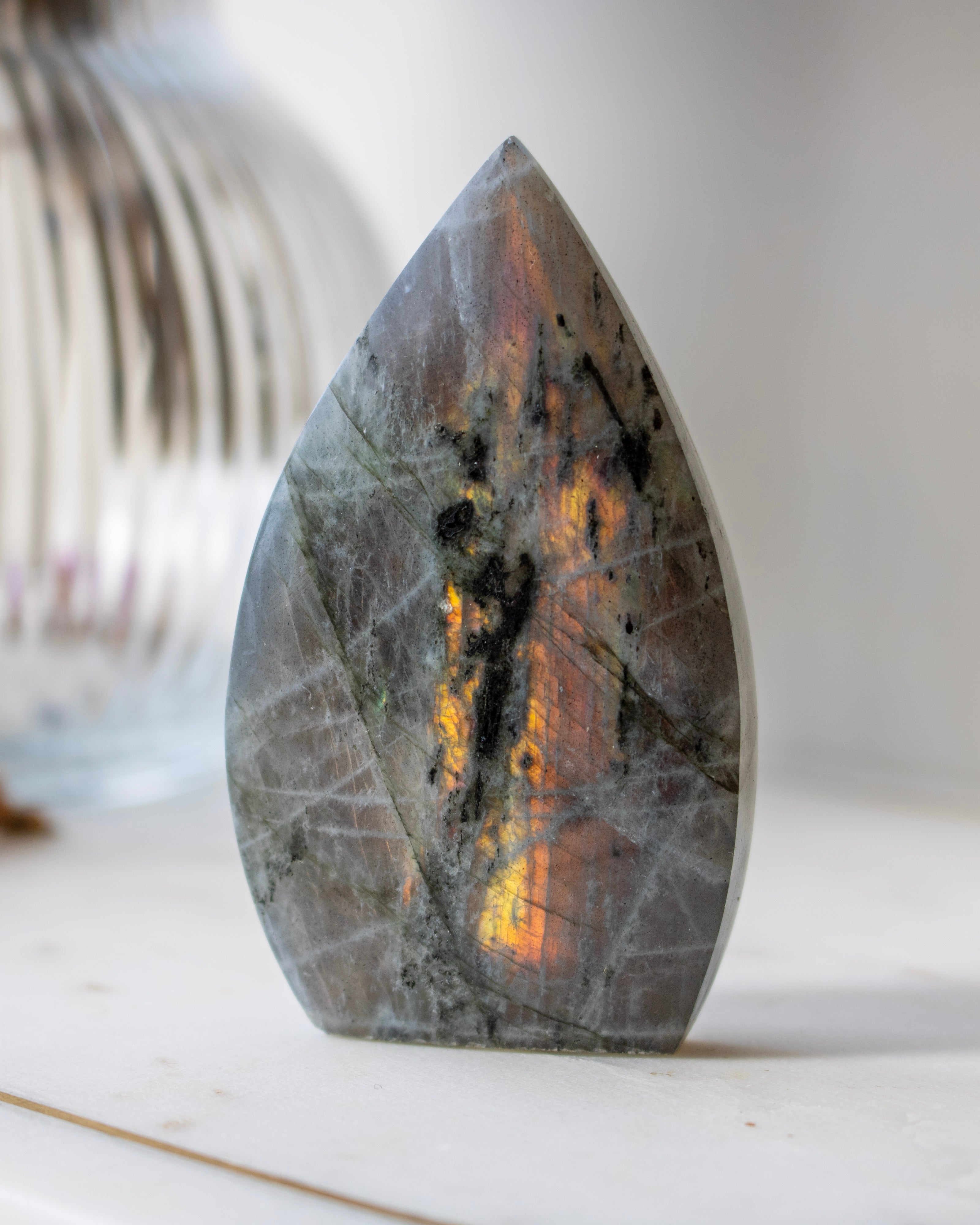 Teardrop-shaped stone with marbled pattern on a neutral background
