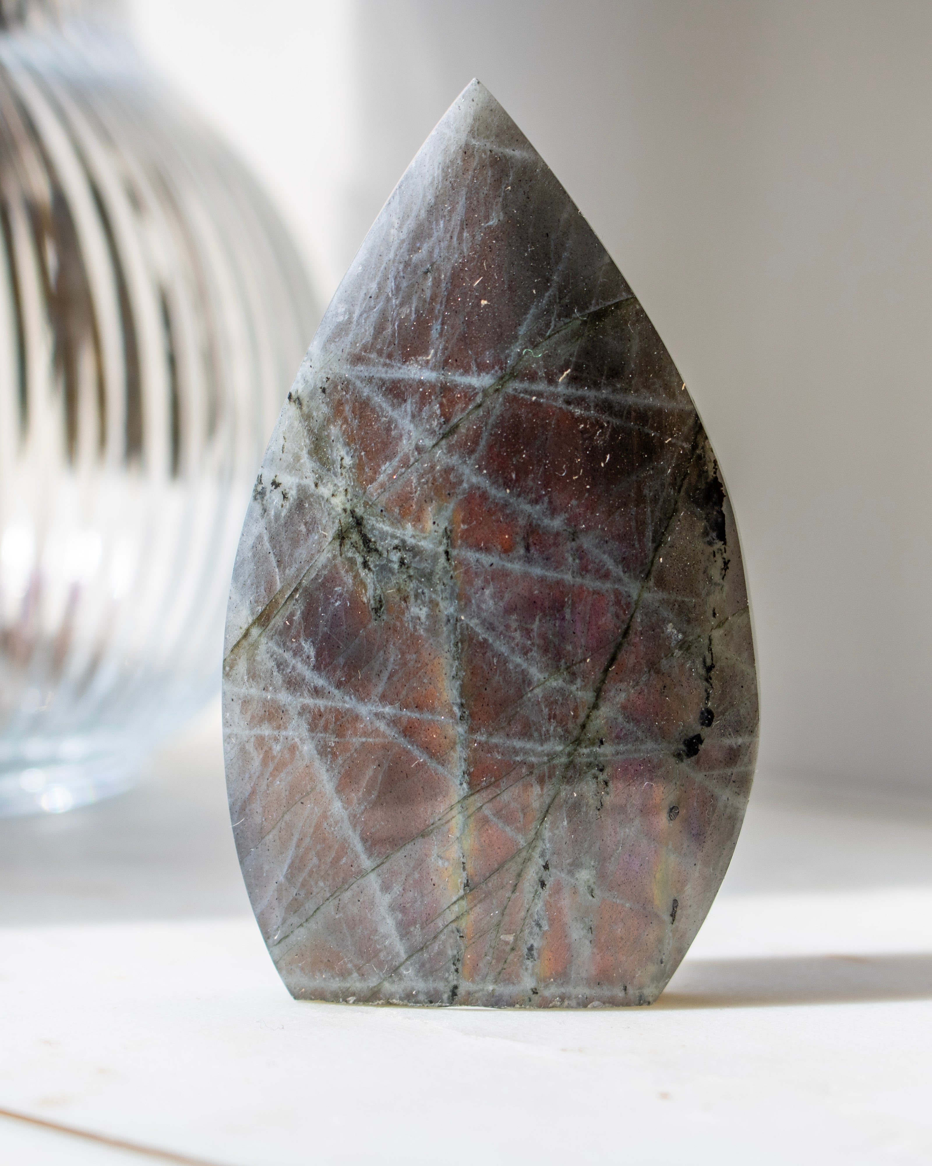 Teardrop-shaped stone with marbled pattern on a neutral background