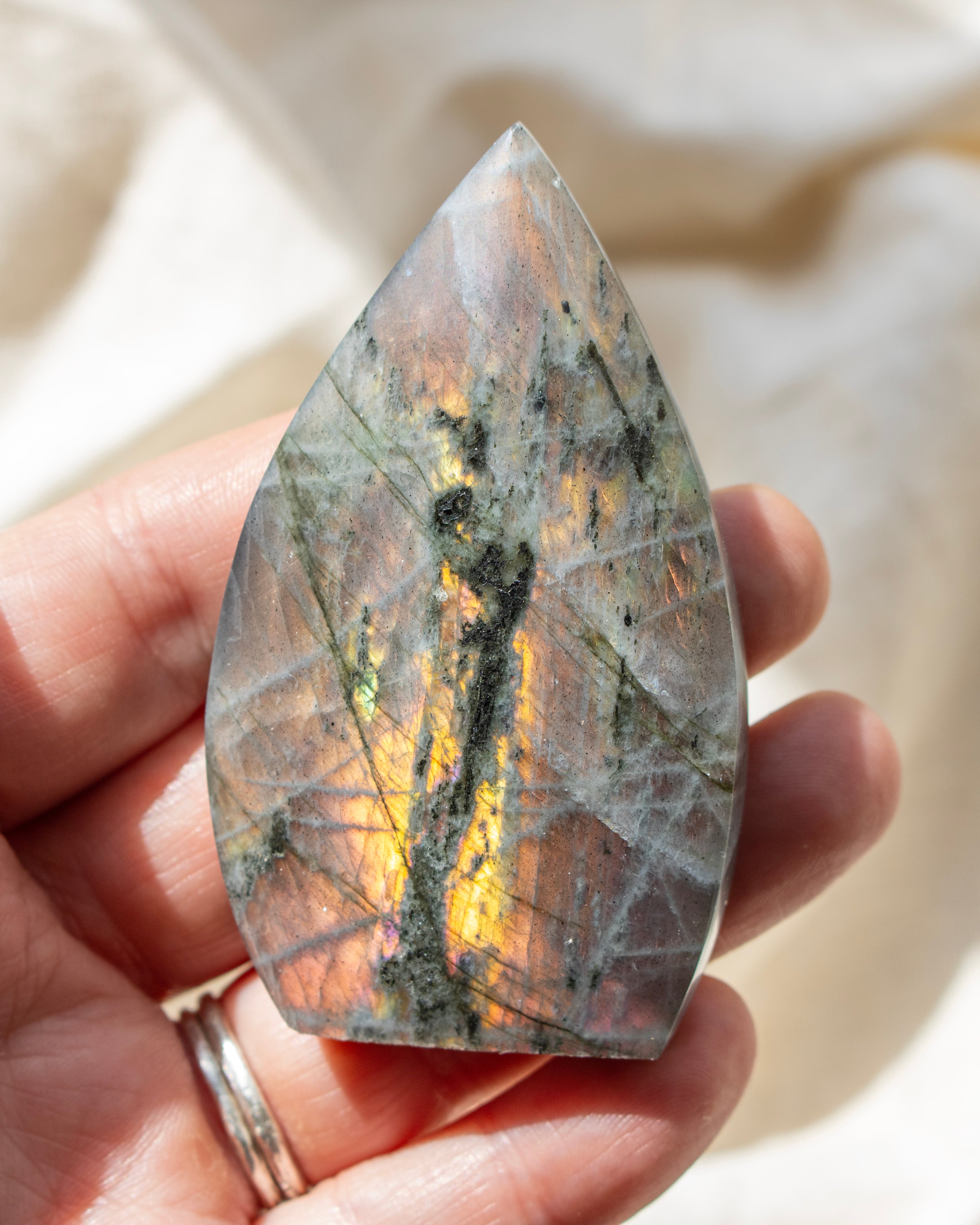 Teardrop-shaped stone with marbled pattern on a neutral background