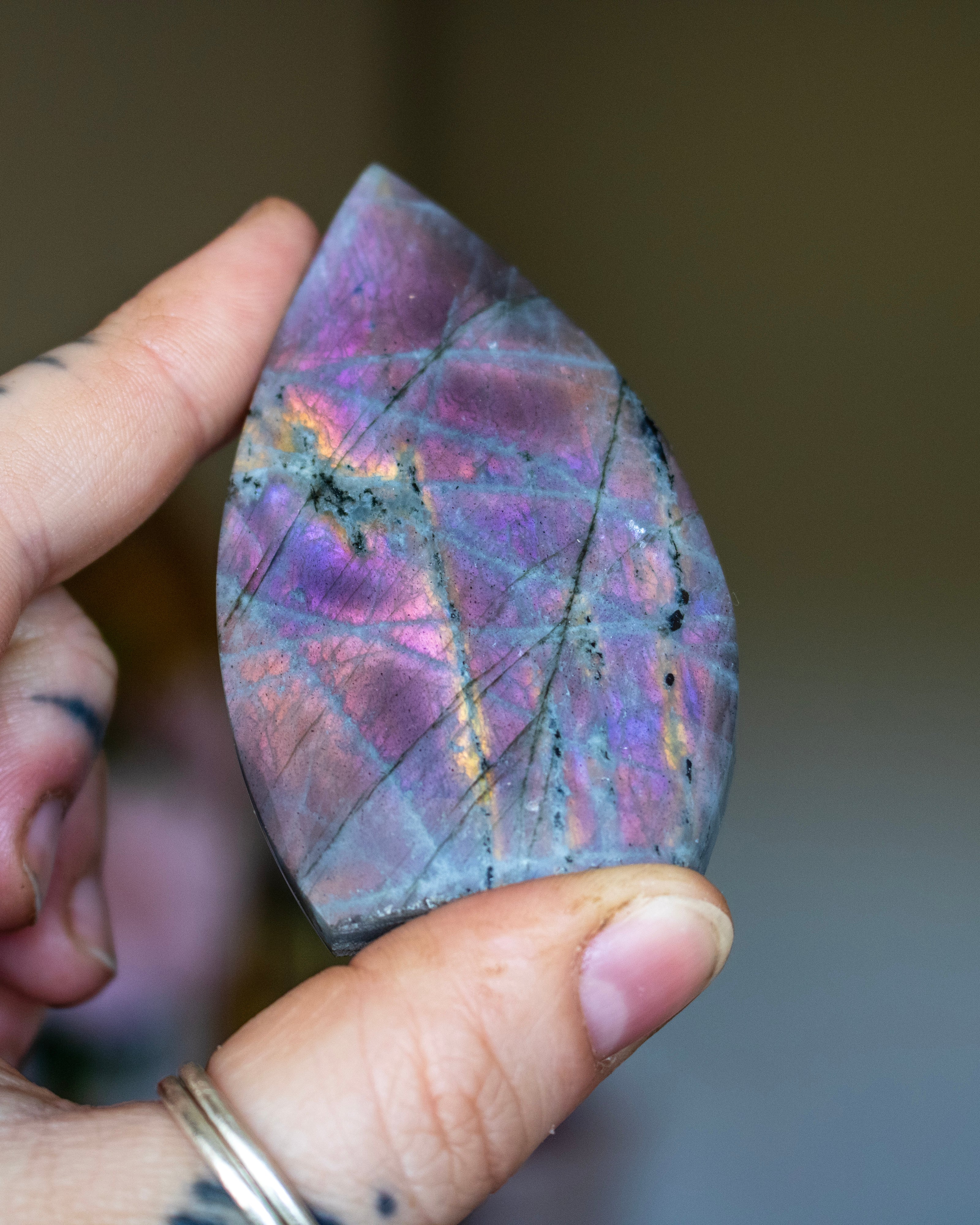 Teardrop-shaped stone with marbled pattern on a neutral background