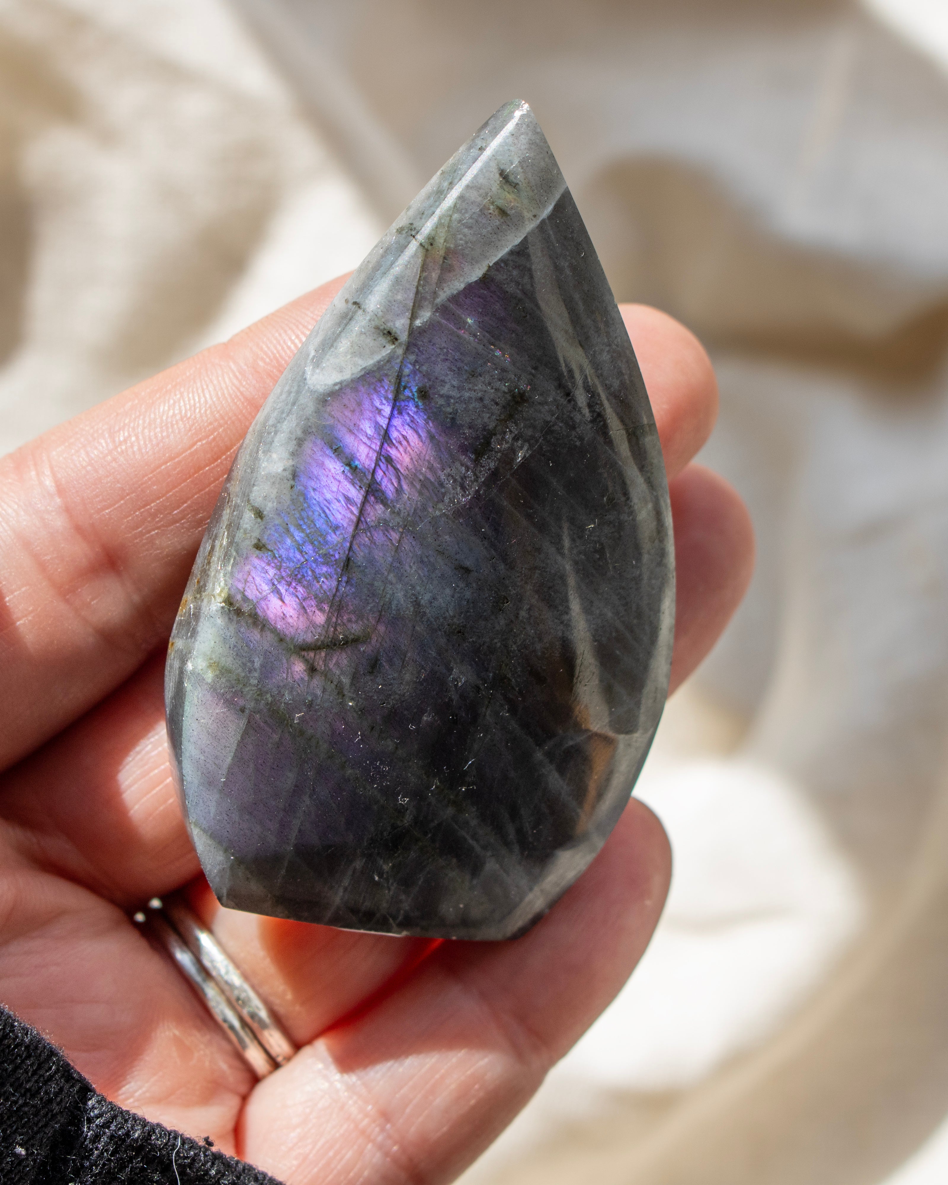 Teardrop-shaped crystal with multicolored patterns on a neutral background